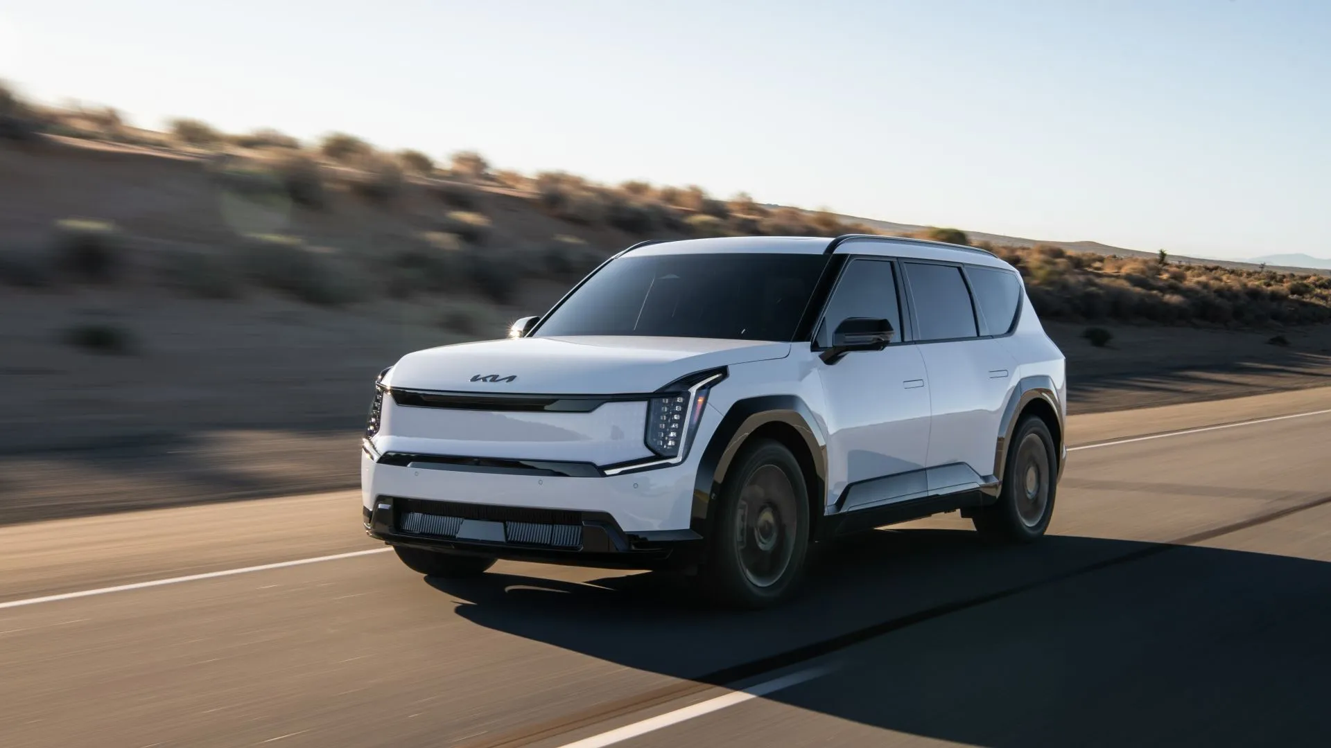 Kia EV9 2025 màu xanh đang di chuyển, nổi bật với thiết kế vuông vắn