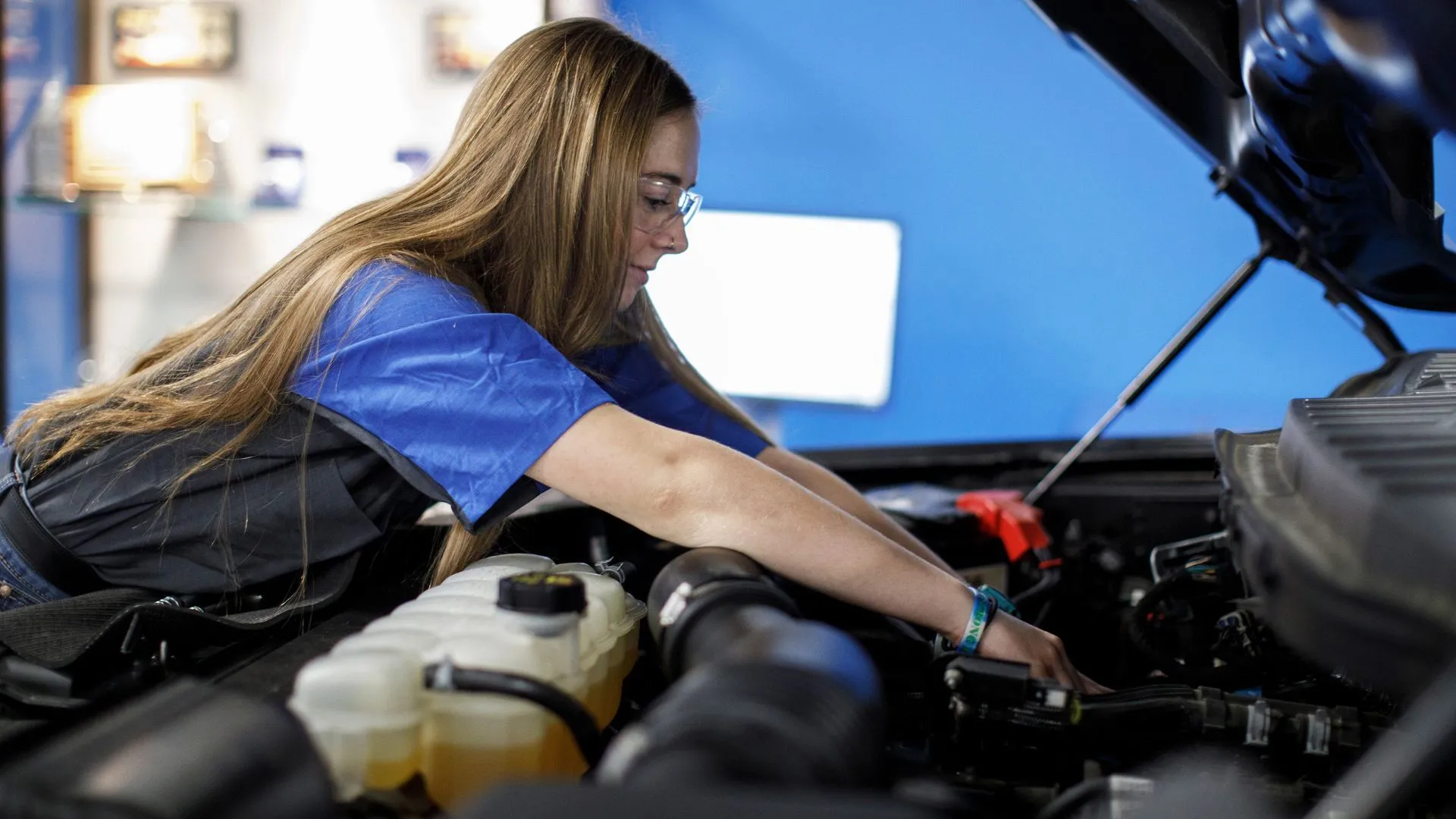 Kỹ thuật viên Ford đang kiểm tra động cơ dưới nắp capo, biểu tượng cho dịch vụ bảo hành và kiểm tra xe Ford EcoBoost.