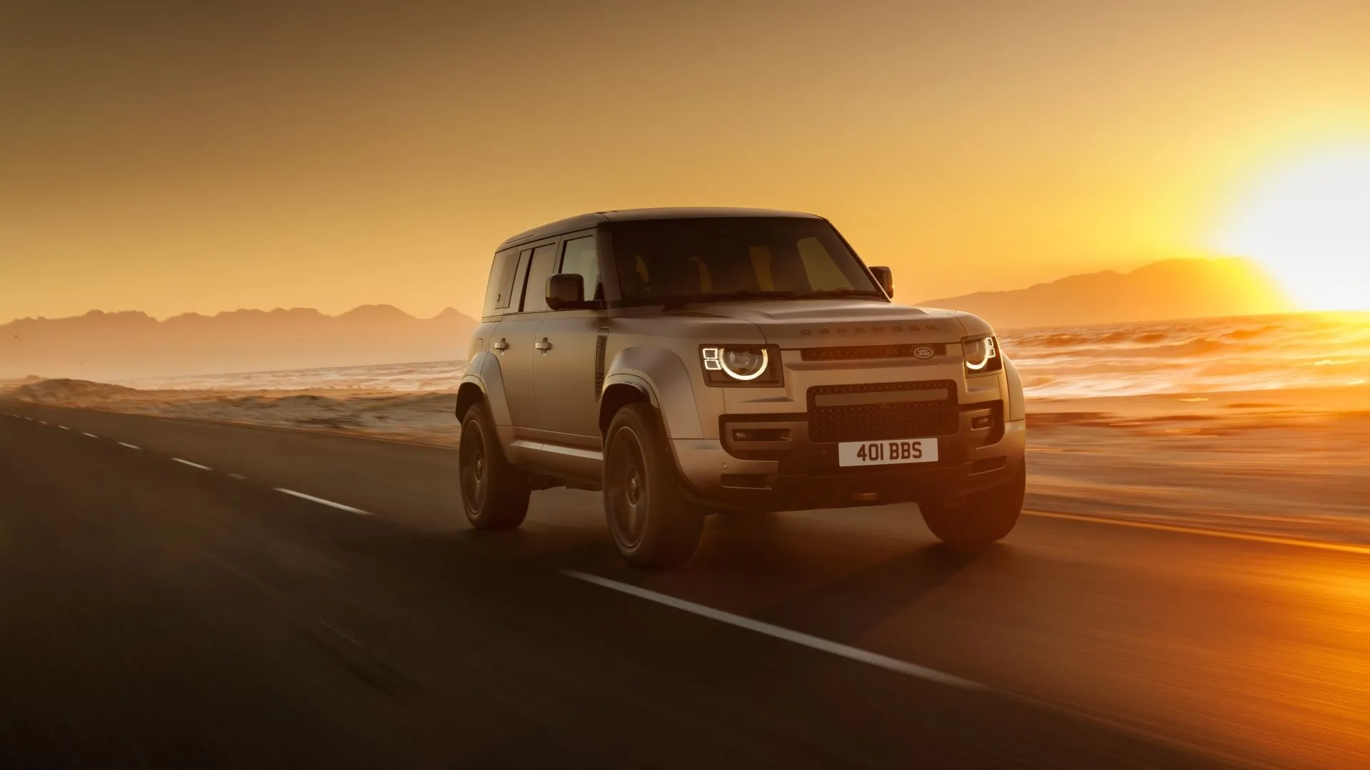 Land Rover Defender 2025 màu xám bạc đang di chuyển, thể hiện sự sang trọng và mạnh mẽ