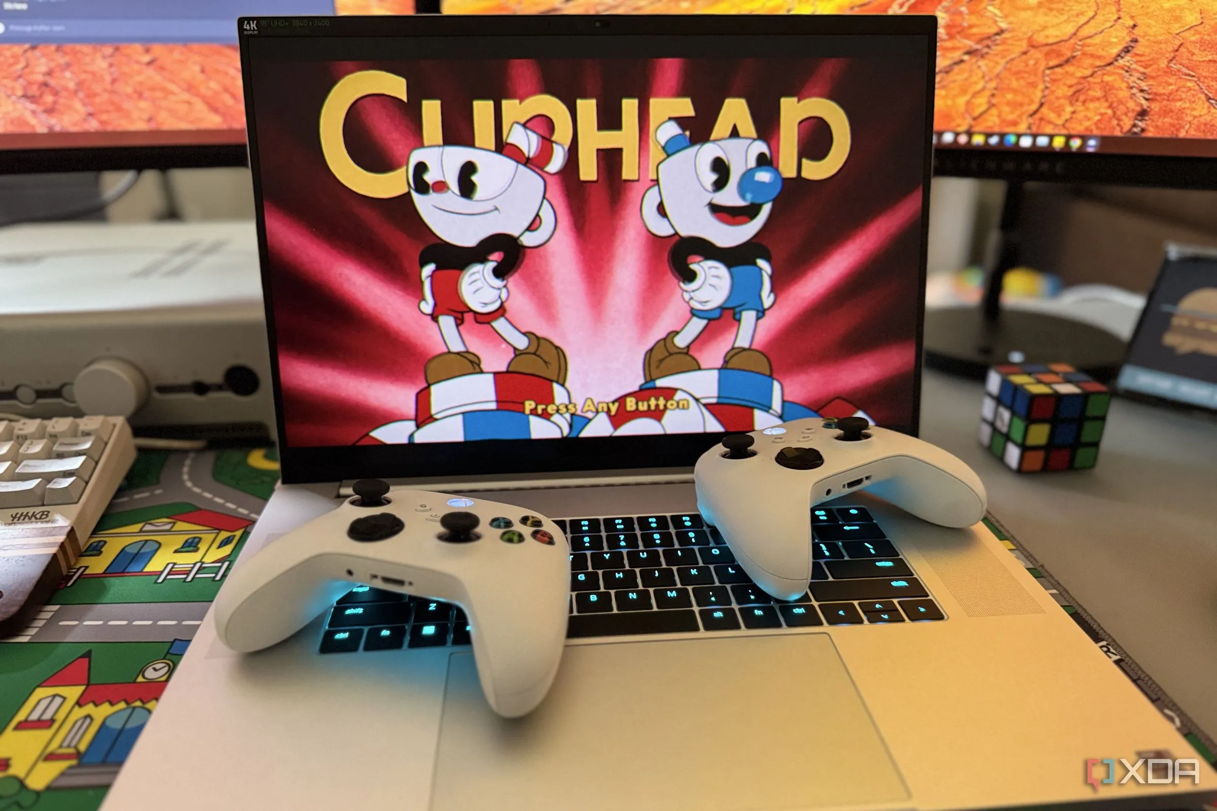 Laptop gaming Razer Blade 18 chạy game Cuphead với hai tay cầm Xbox, trải nghiệm chơi game mượt mà.