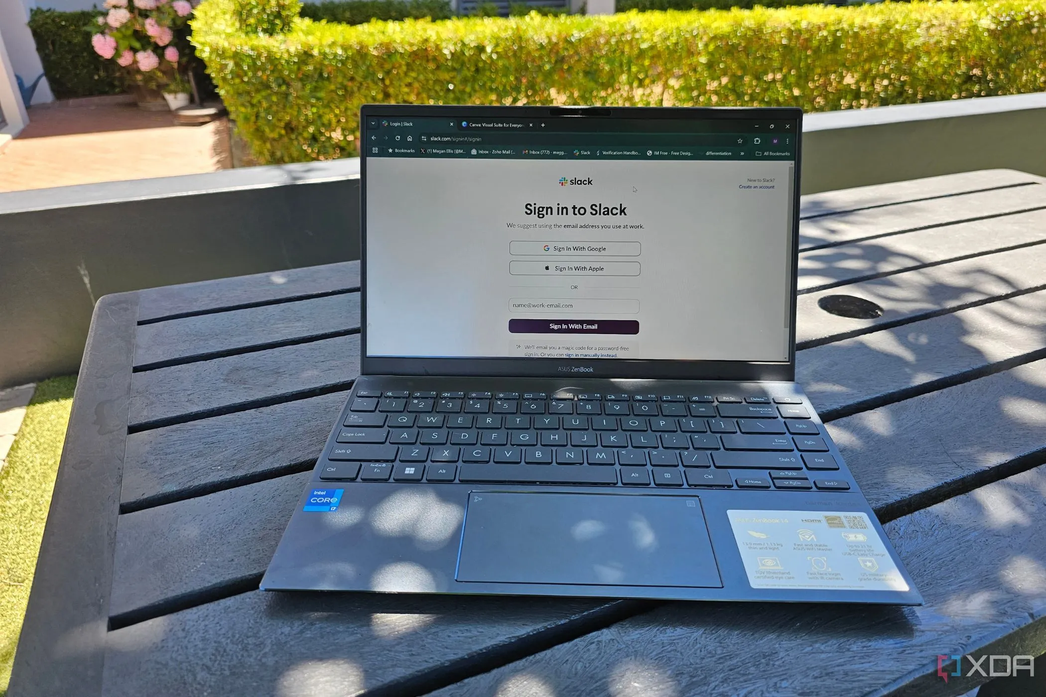 Laptop hiển thị màn hình đăng nhập Slack đặt ngoài trời, minh họa khả năng hiển thị tốt của màn hình E Ink dưới ánh nắng