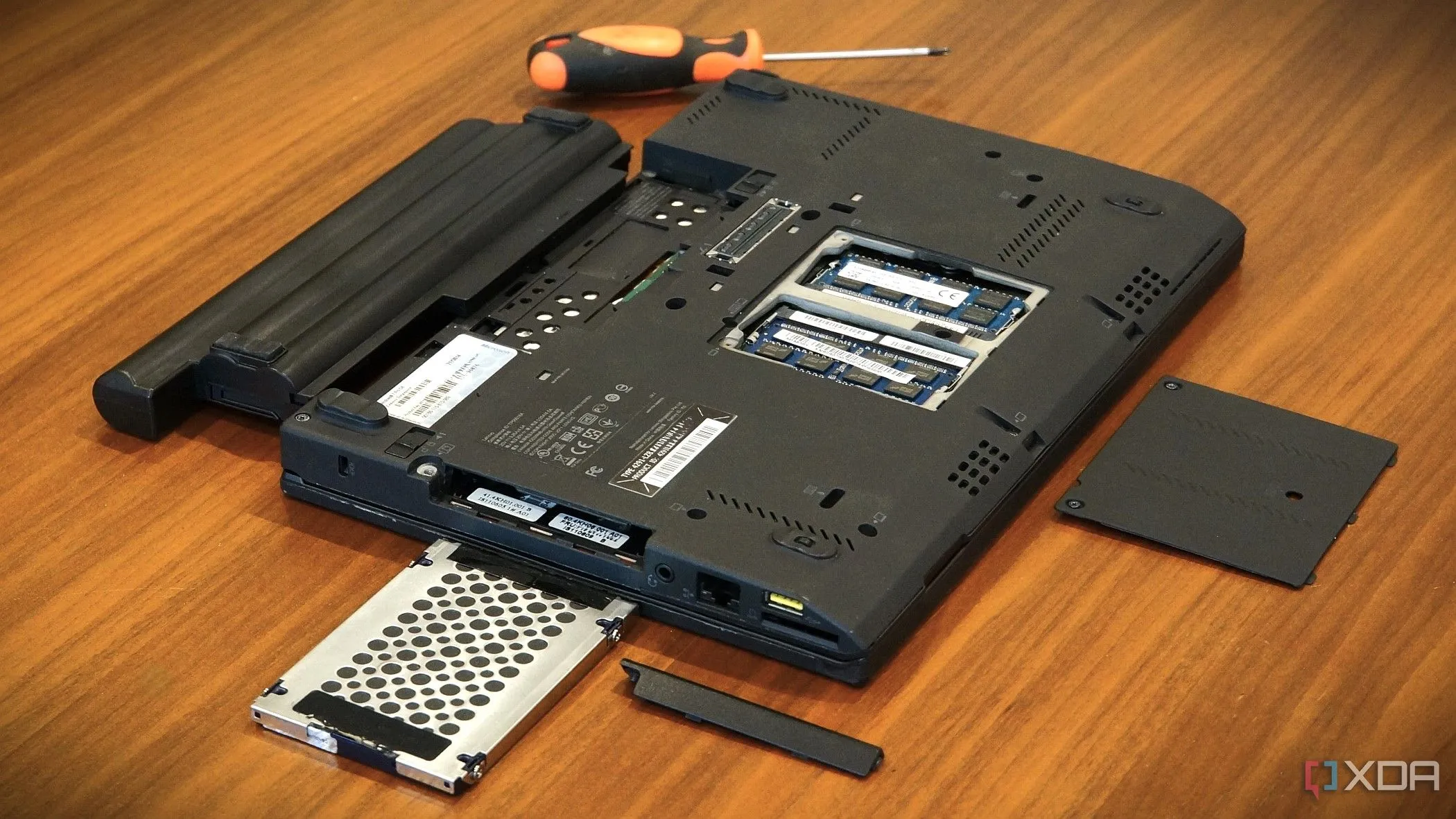 Laptop Lenovo x220 mở nắp, cho thấy vị trí pin đã tháo rời và các khe nâng cấp khác, minh họa việc thay pin laptop