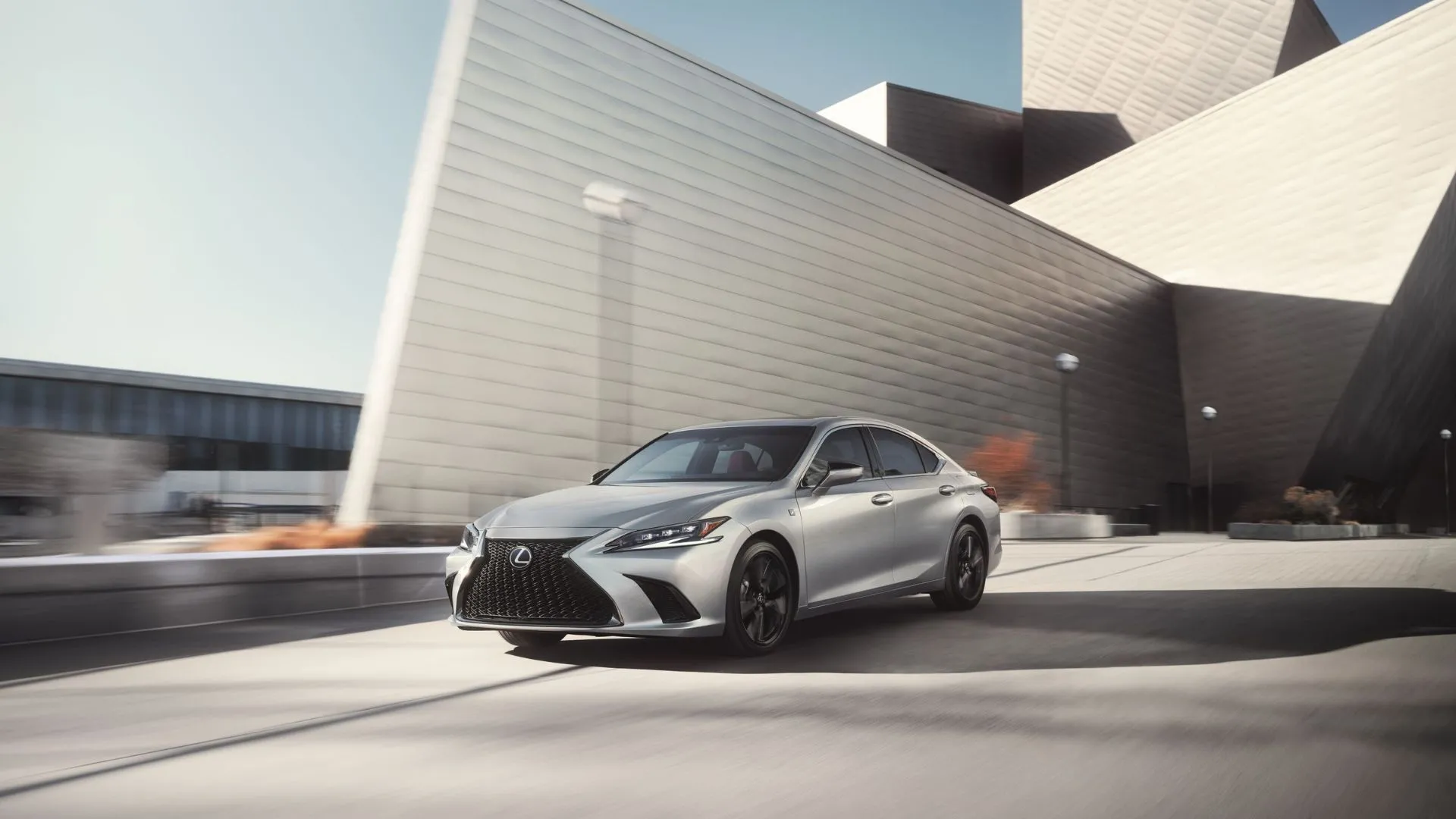 Lexus ES 300h 2025 màu bạc lướt đi trên đường phố đô thị, biểu tượng của sự sang trọng và công nghệ hybrid cao cấp