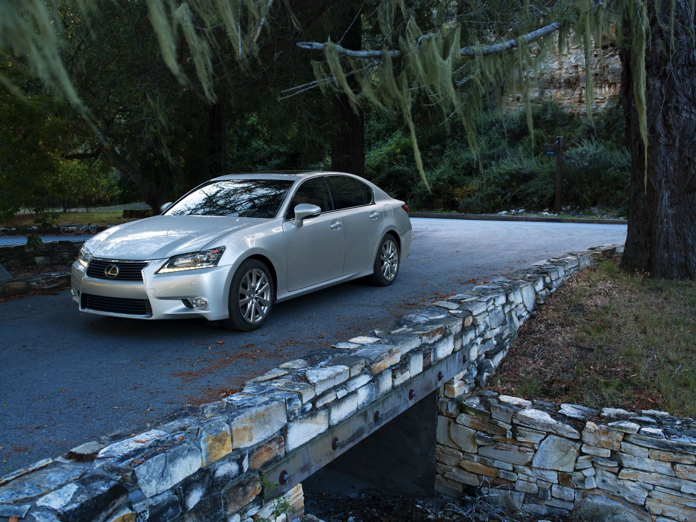 Lexus GS 350 2015 màu bạc đỗ trên một cây cầu đá
