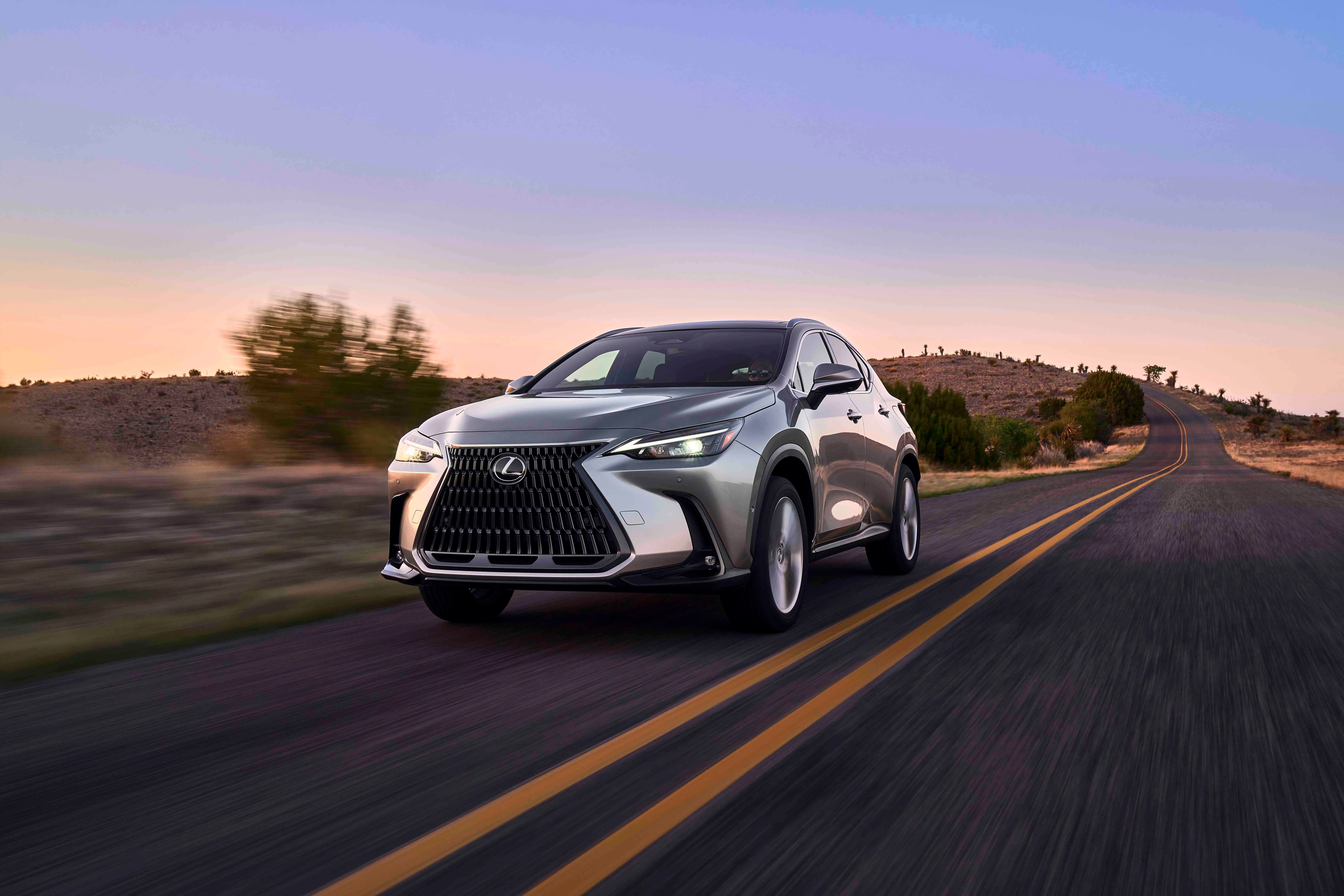 Lexus NX 350h 2024 màu bạc chạy trên đường nông thôn, minh họa thiết kế hiện đại và khả năng vận hành êm ái của SUV cỡ nhỏ.