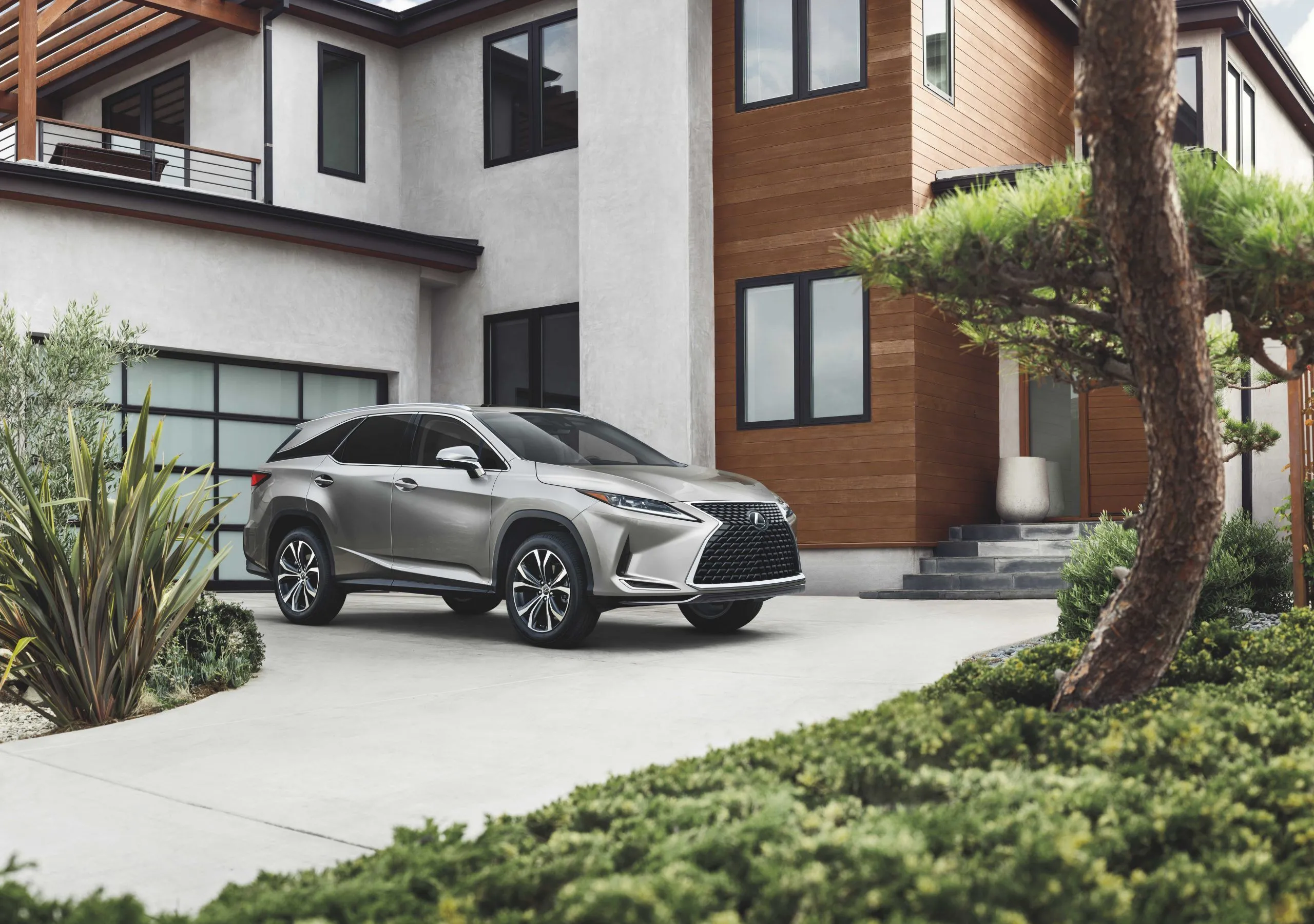 Lexus RX 350L 2022 màu bạc đỗ trên đường lái xe của một ngôi nhà
