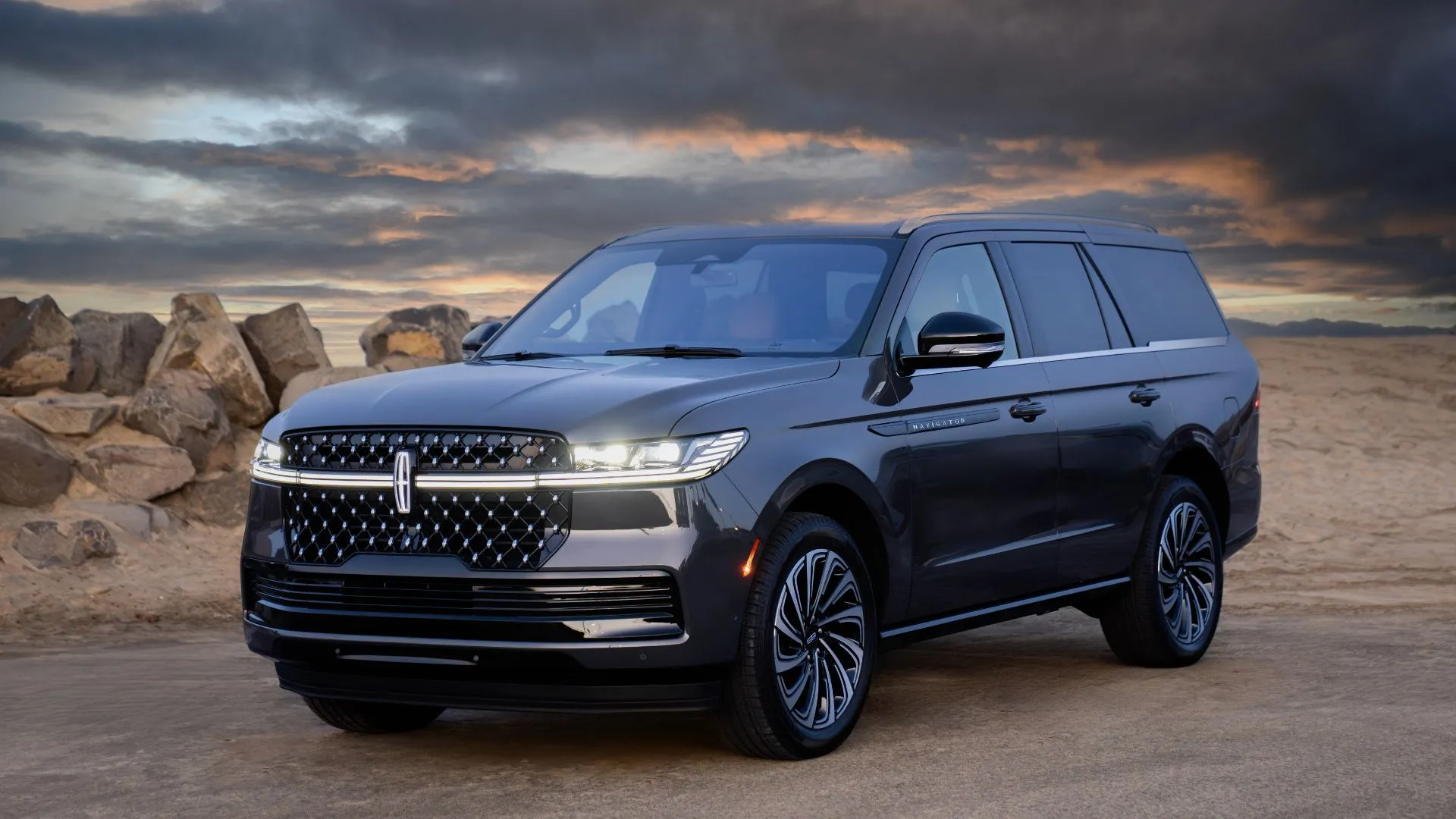 Lincoln Navigator Black Label 2025 với khung cảnh đá và bầu trời mây.