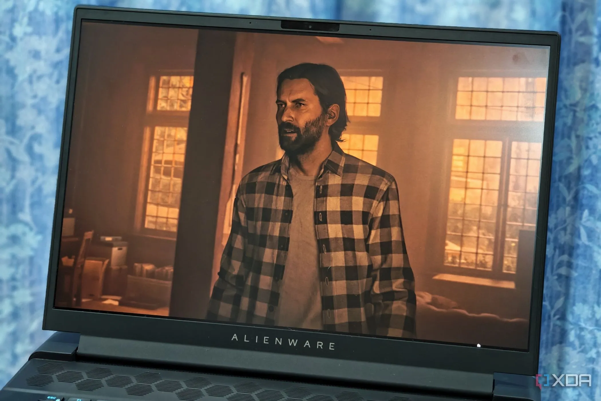 Màn hình Alienware m16 hiển thị cảnh game Alan Wake 2 với đồ họa chất lượng cao