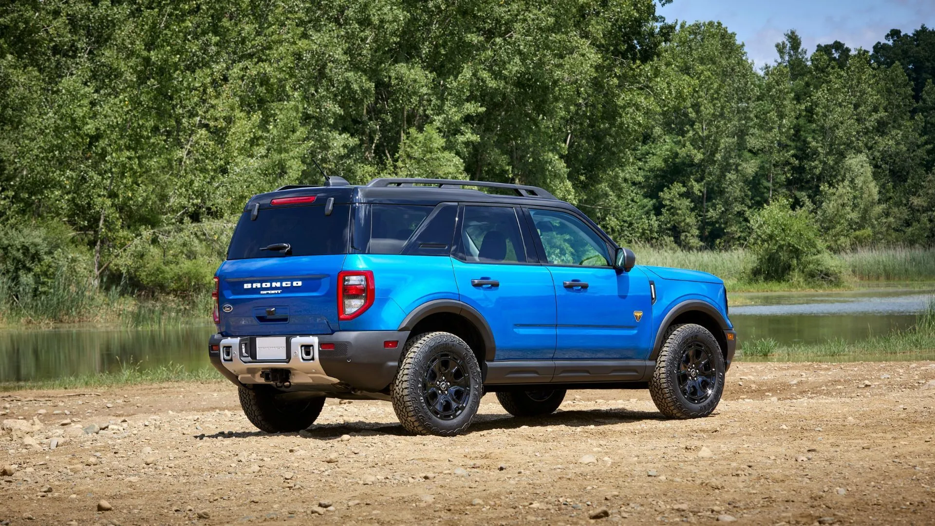 Mẫu SUV Ford Bronco Sport 2025 màu xanh đỗ trên đường sỏi, đại diện cho xe Bronco bị lỗi khóa trẻ em.