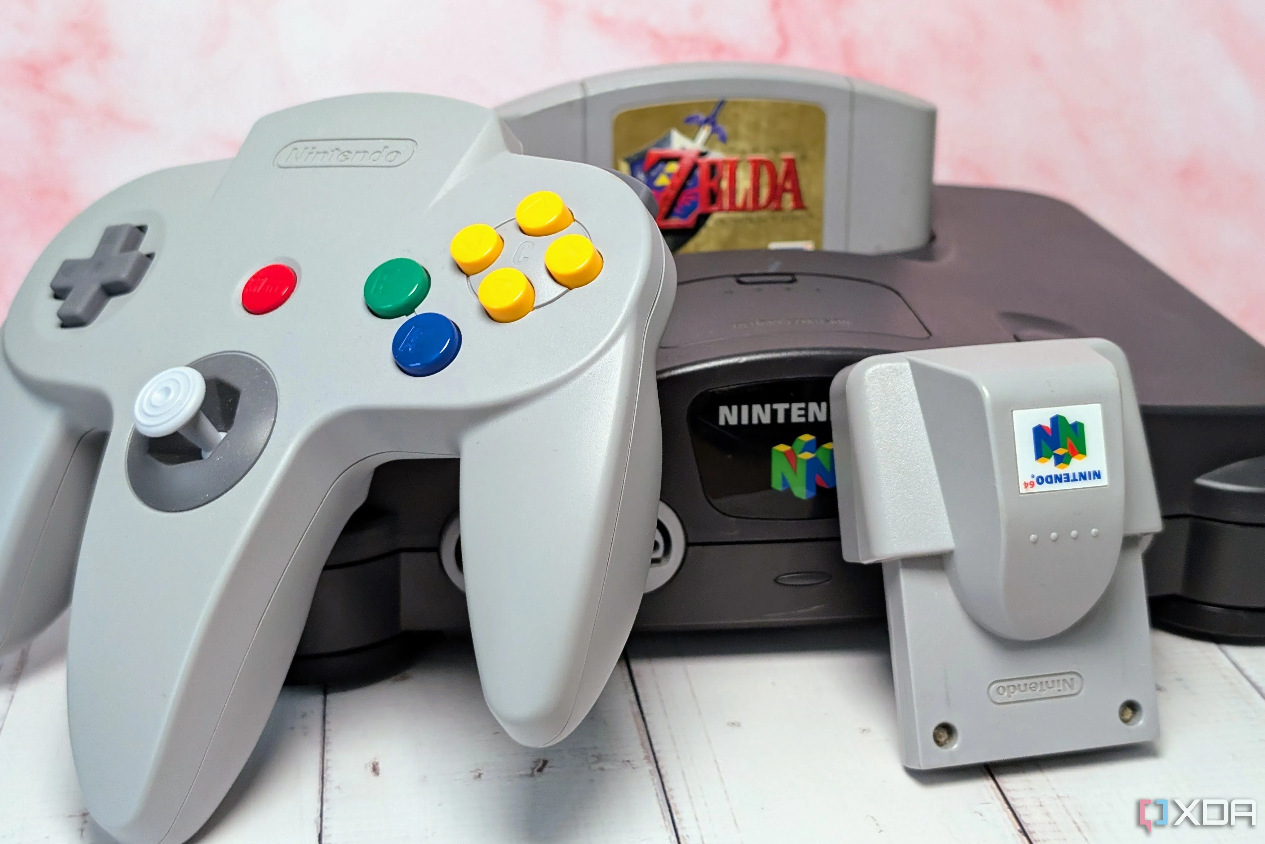 Máy chơi game Nintendo 64 và băng trò chơi Ocarina of Time cùng tay cầm Rumble Pak, biểu tượng của kỷ nguyên game 3D.