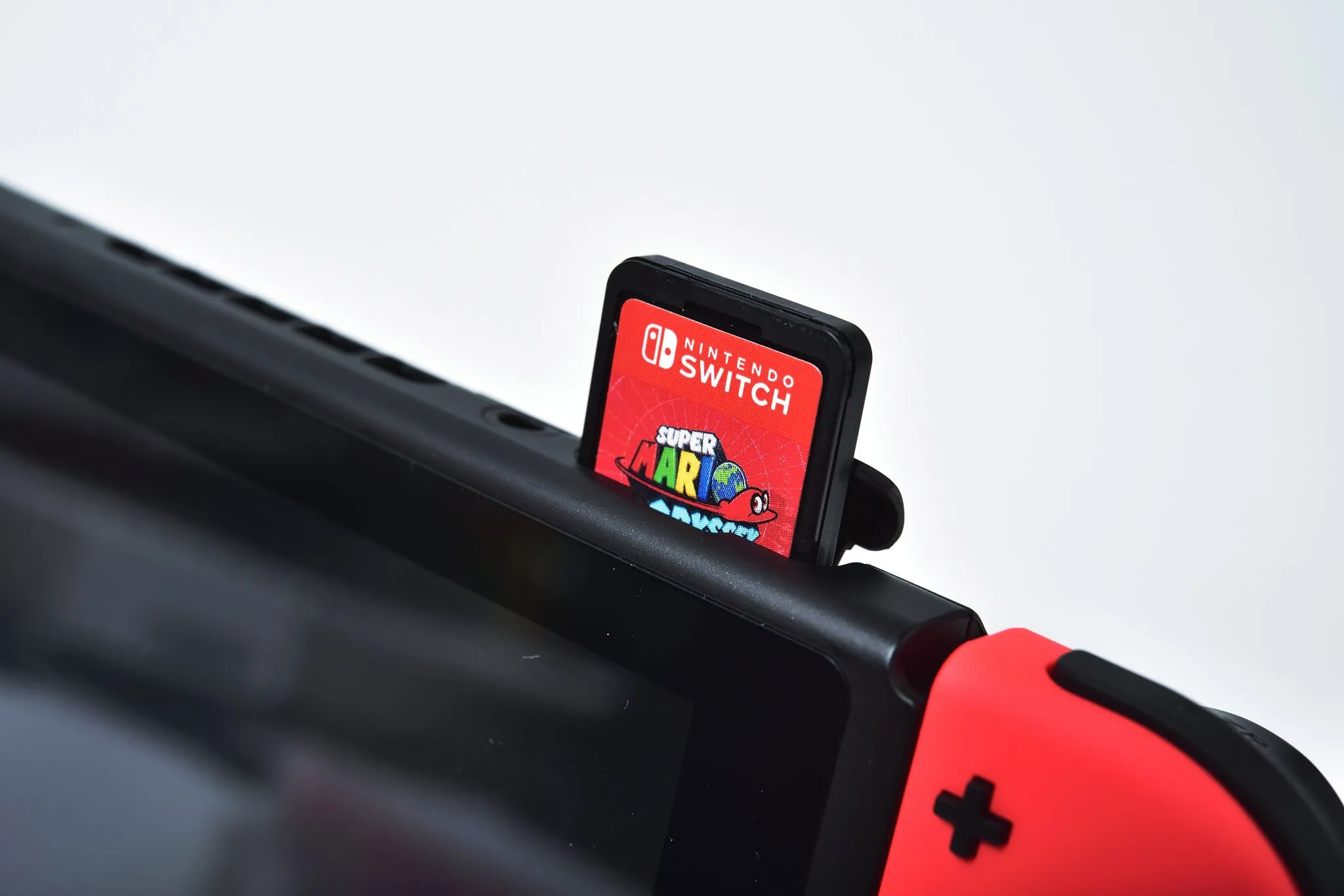 Máy chơi game Nintendo Switch với thẻ game được cắm vào khe cắm, biểu tượng cho trải nghiệm game trên console