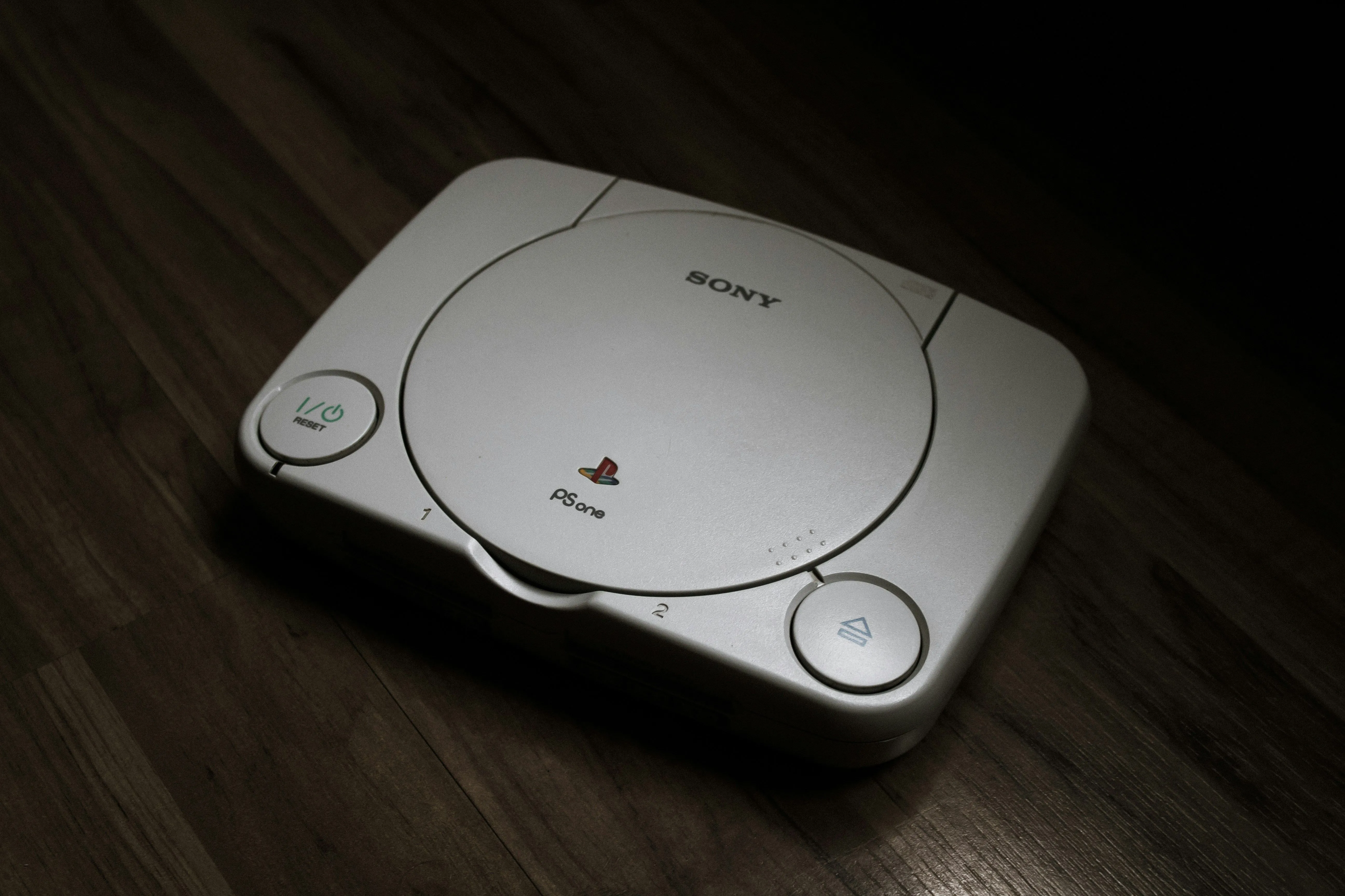 Máy chơi game PlayStation 1 đặt trên sàn gỗ, đánh dấu một kỷ nguyên mới của console
