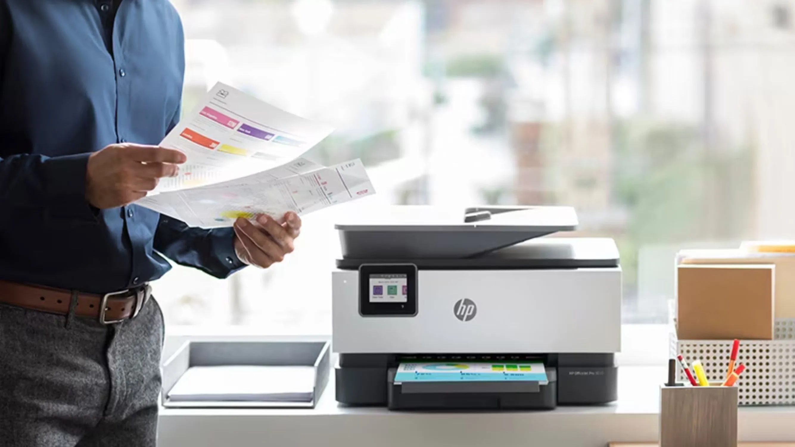 Máy in đa năng HP màu đen đặt trên bàn làm việc