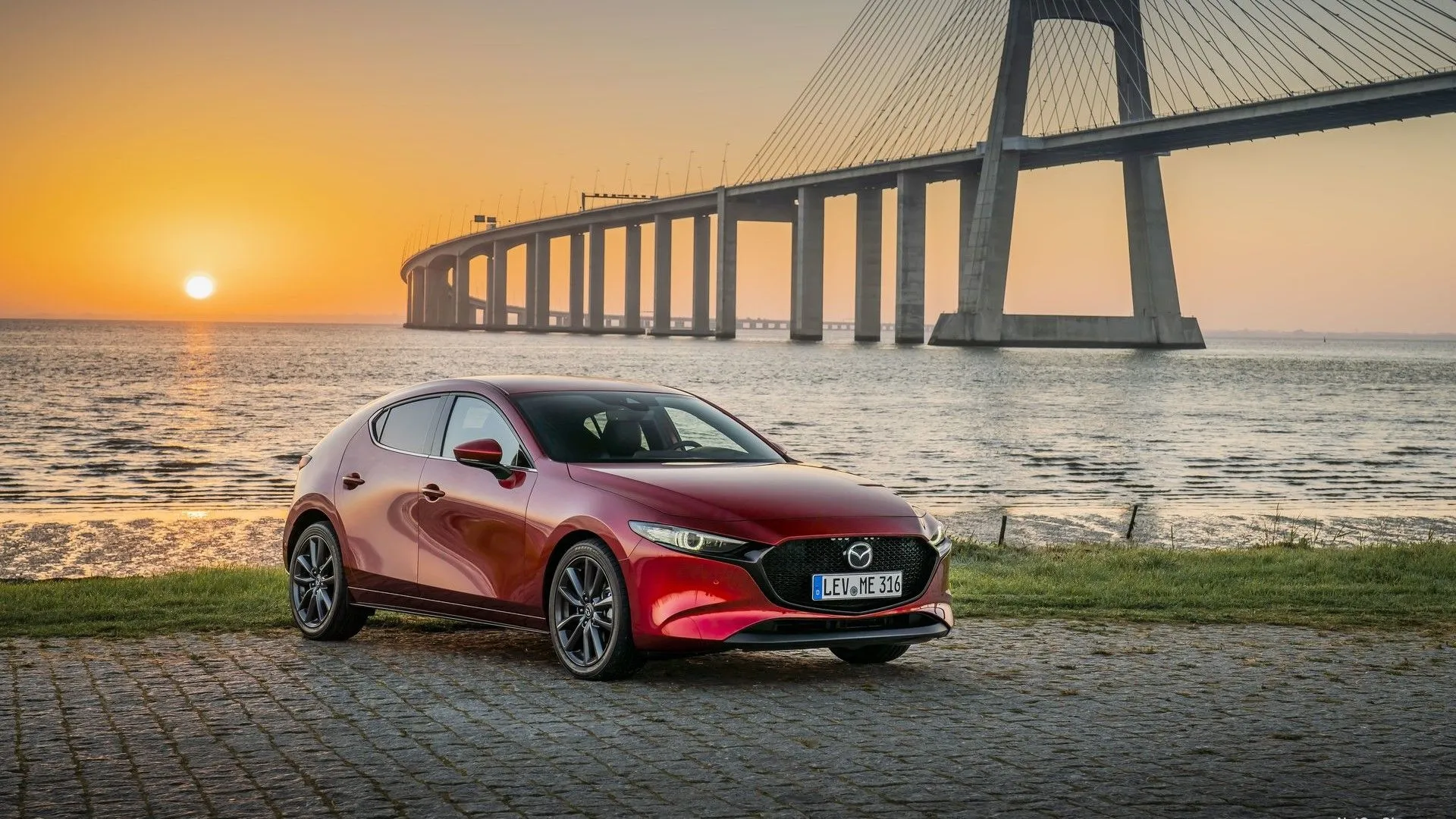 Mazda 3 2019 màu xám đỗ trước cầu, góc 3/4 phía trước