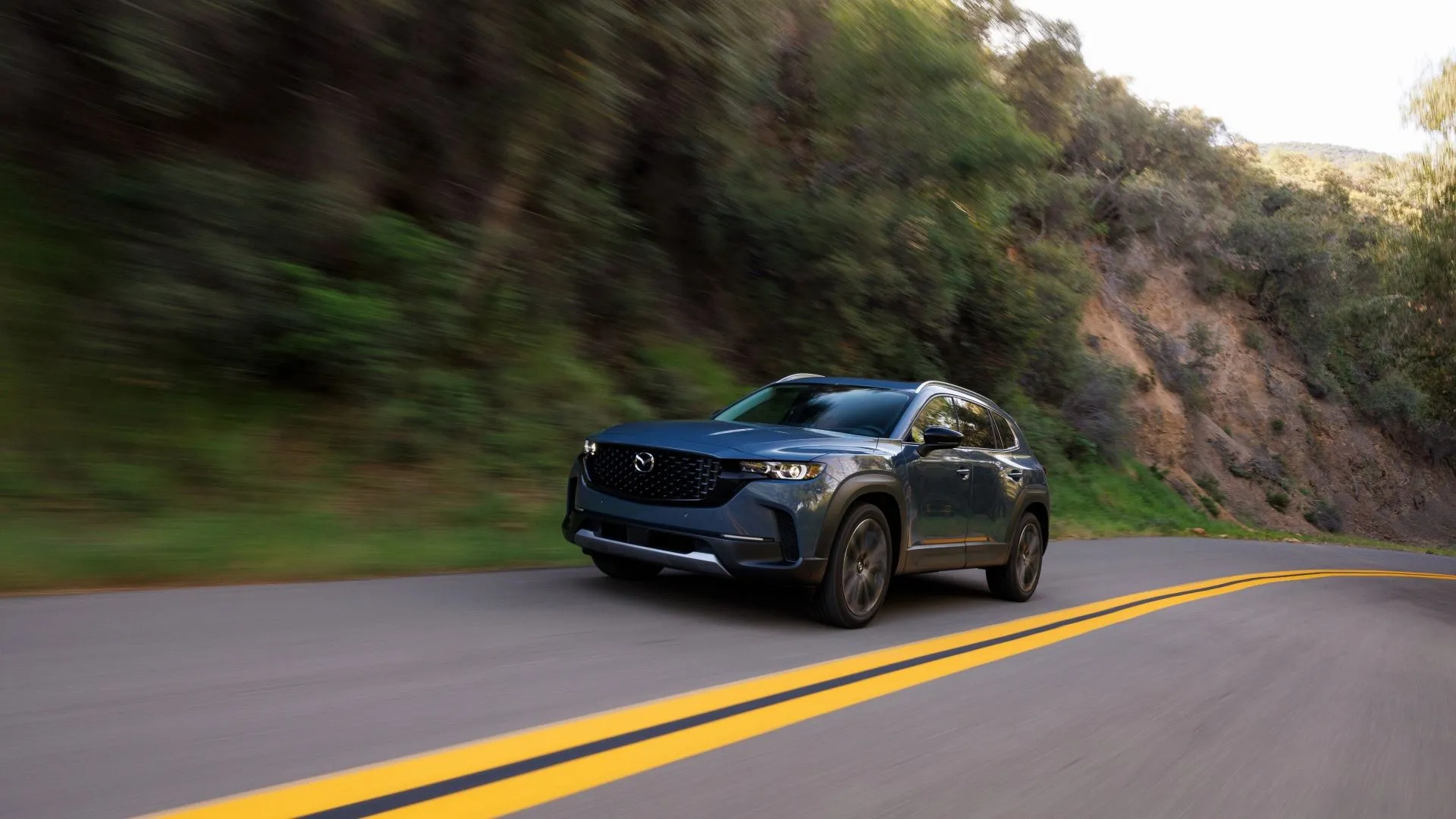 Mazda CX-50 2025 đang vận hành trên đường, thể hiện khả năng lái thể thao và linh hoạt của SUV này