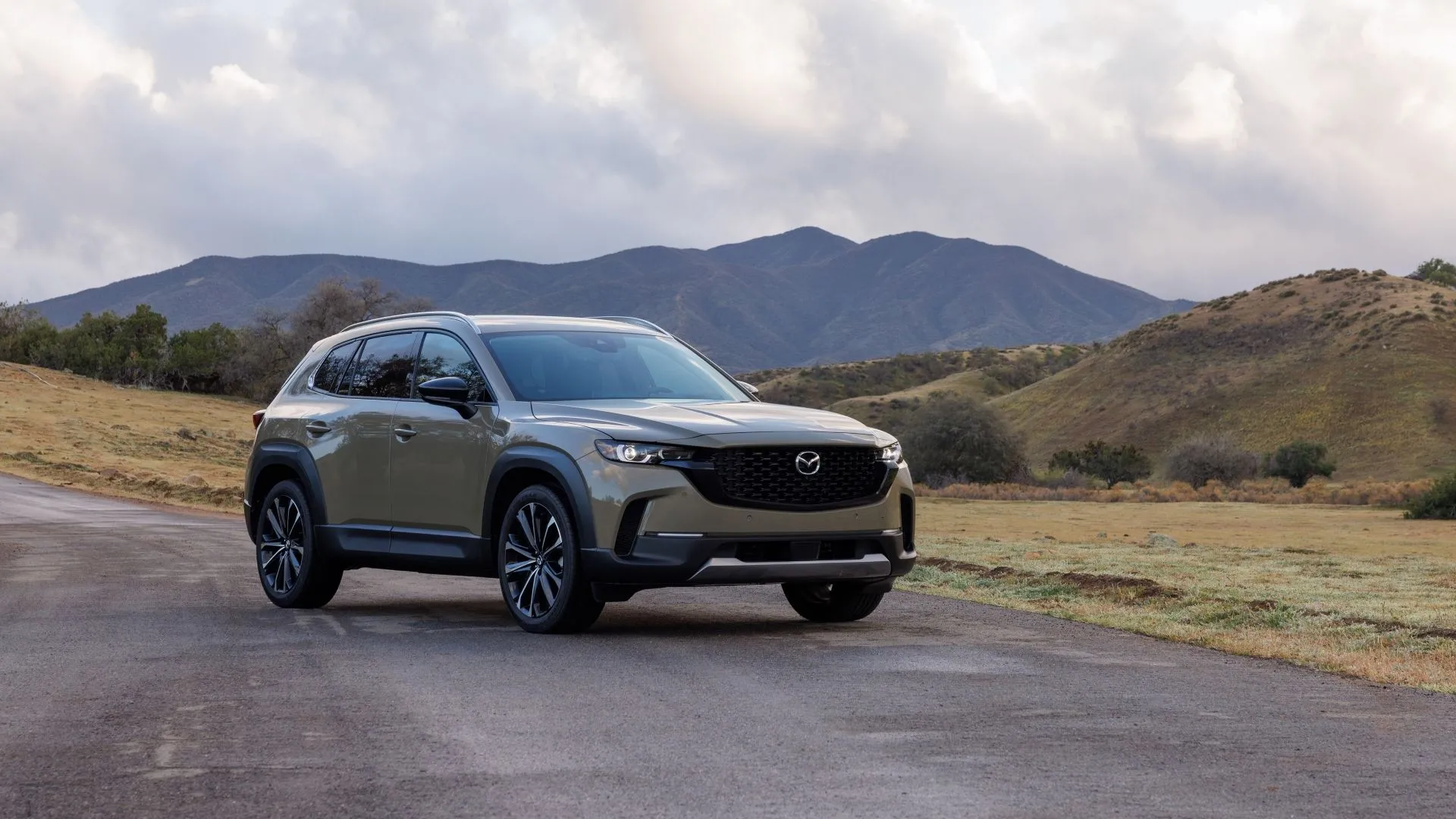 Mazda CX-50 2025 màu xanh rêu với thiết kế ngoại thất mạnh mẽ và sang trọng, đỗ trong môi trường tự nhiên.