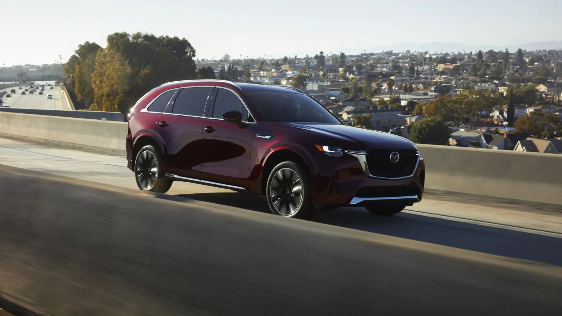 Mazda CX-90 2025 màu đỏ mận sang trọng đang di chuyển