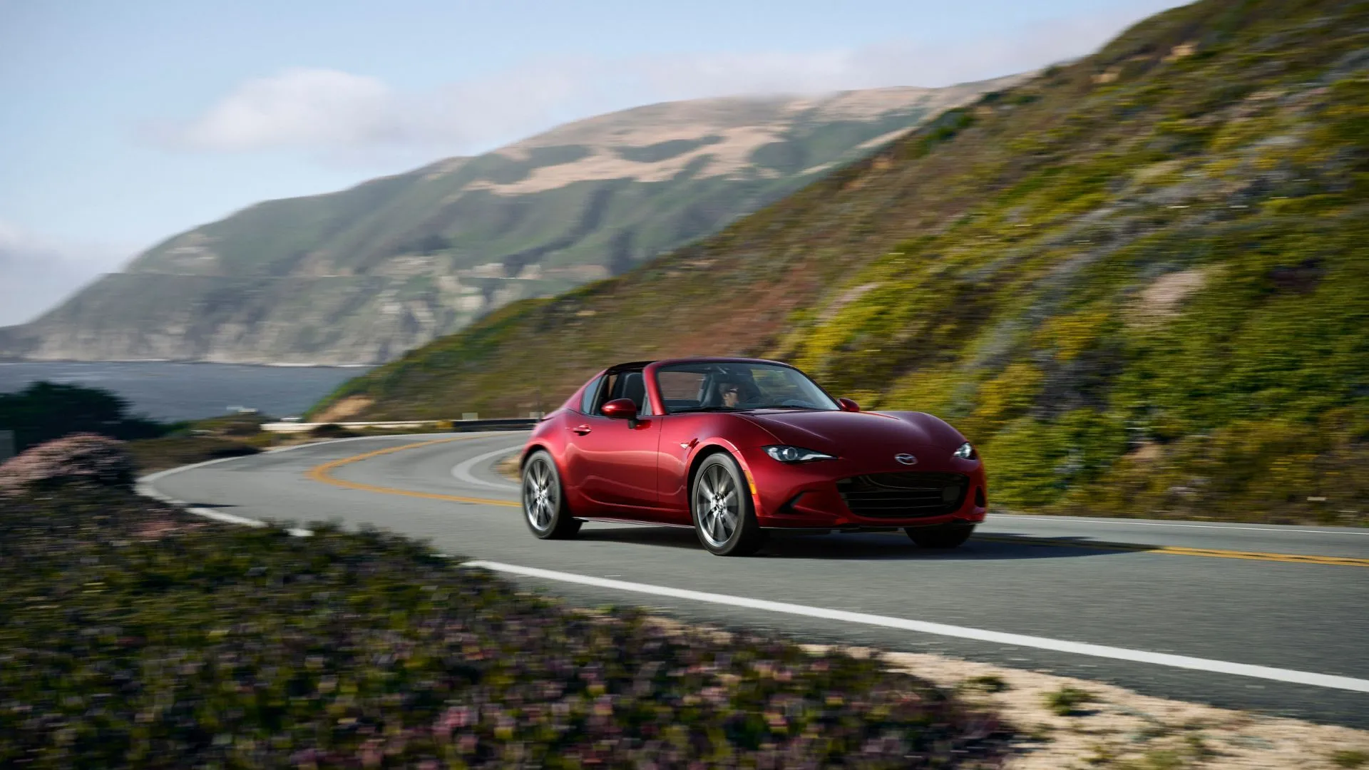 Mazda MX-5 Miata RF 2024 màu đỏ chạy trên đường ven biển