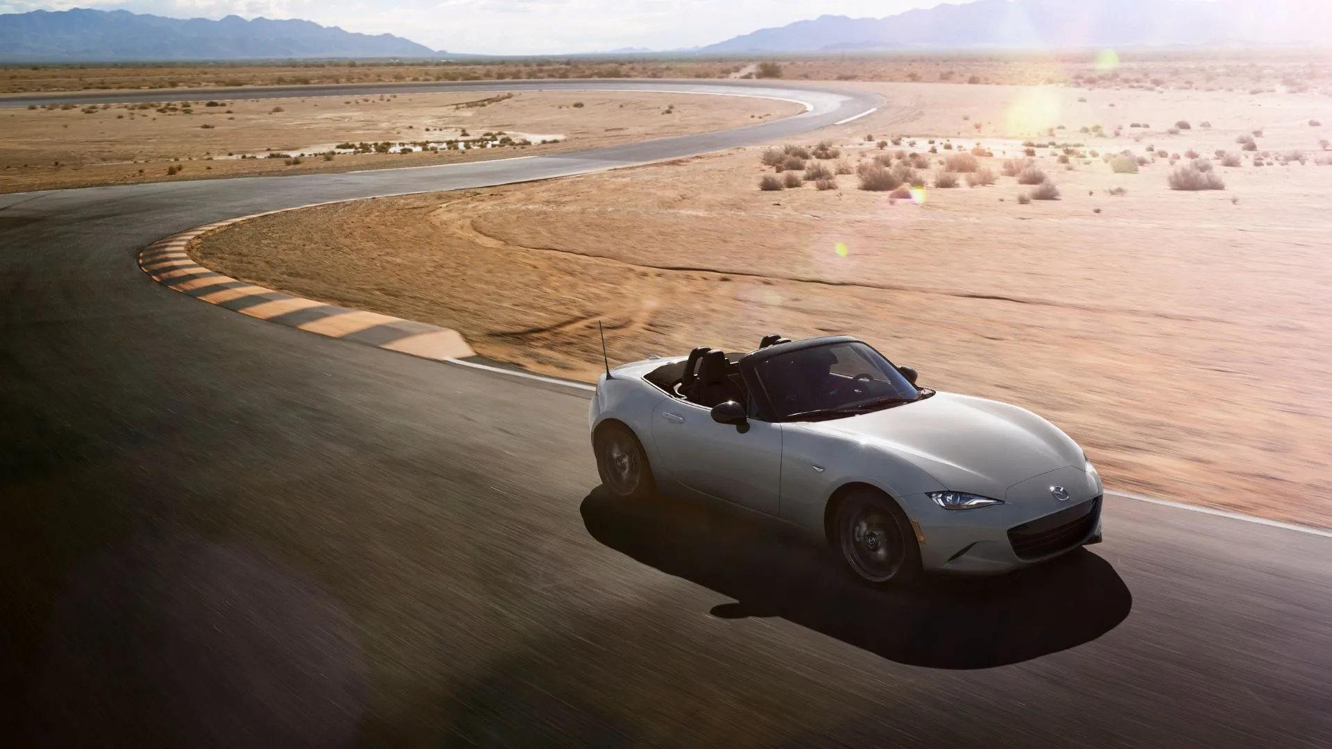 Mazda MX-5 Miata Sport 2024 màu bạc trên đường đua sa mạc, xe mui trần nhẹ nhàng, tối ưu cảm giác lái