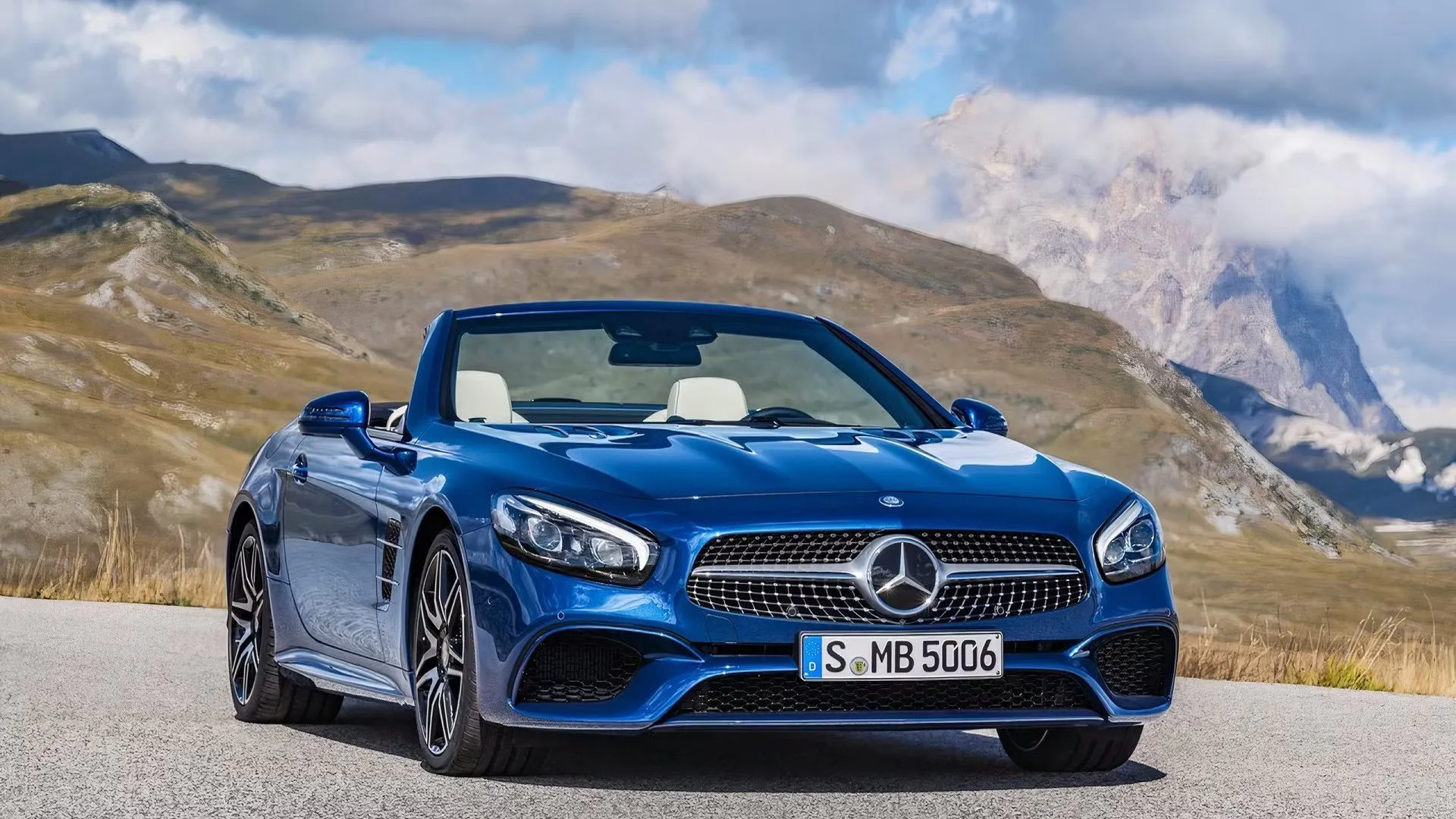 Mercedes-Benz SL-Class màu xanh dương đỗ với mui hạ, núi làm nền