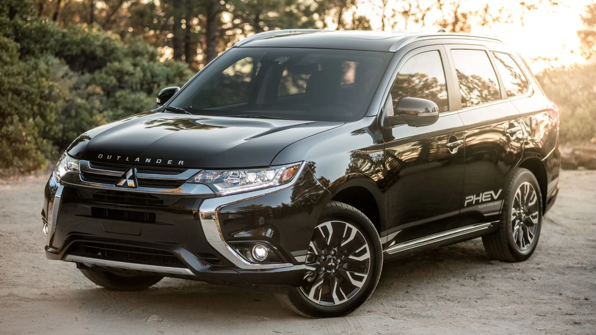 Mitsubishi Outlander PHEV 2018 màu đen đậu trên nền sỏi.