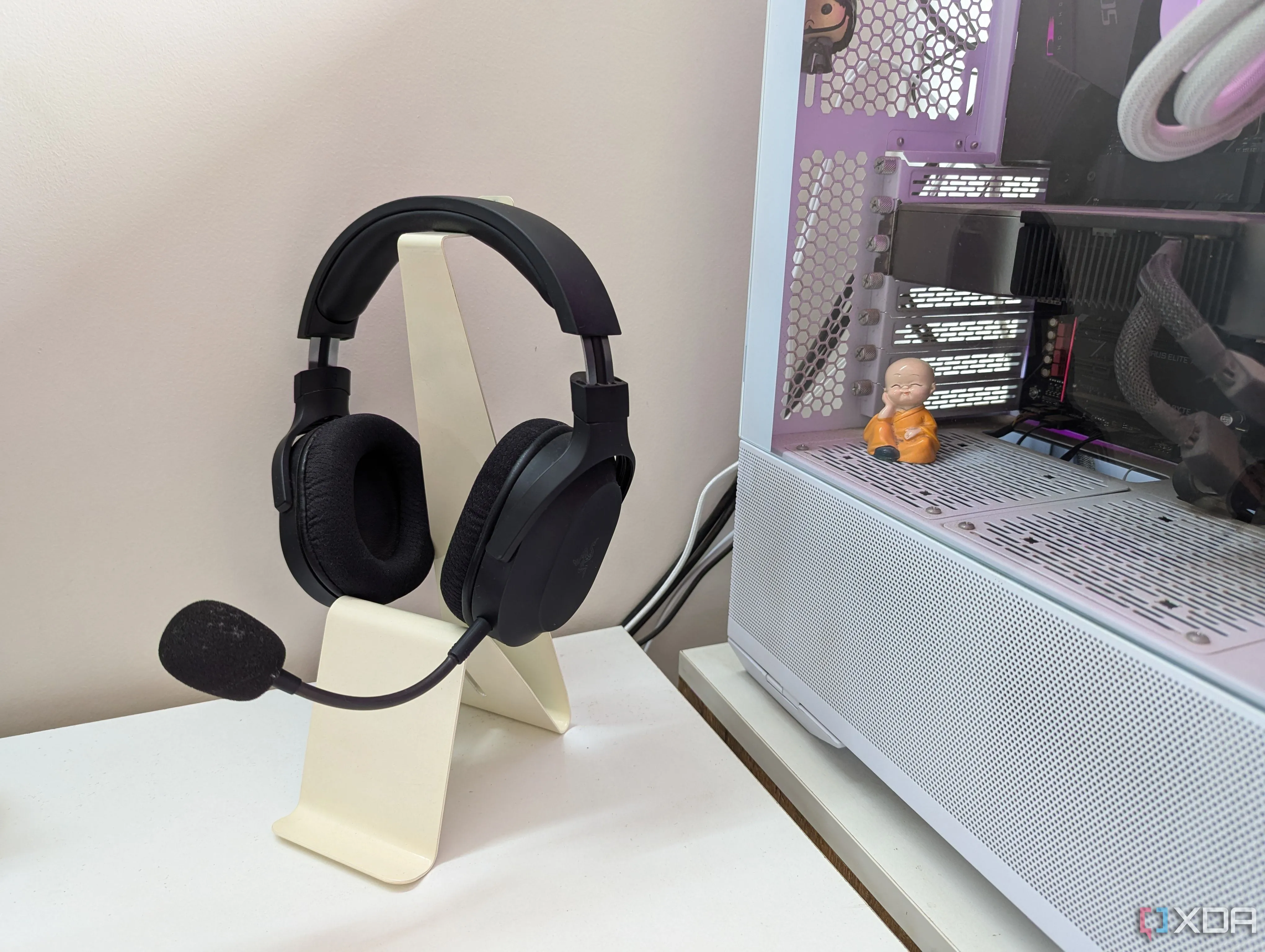 Một bộ tai nghe gaming trên giá đỡ tai nghe mua sẵn bên cạnh PC gaming
