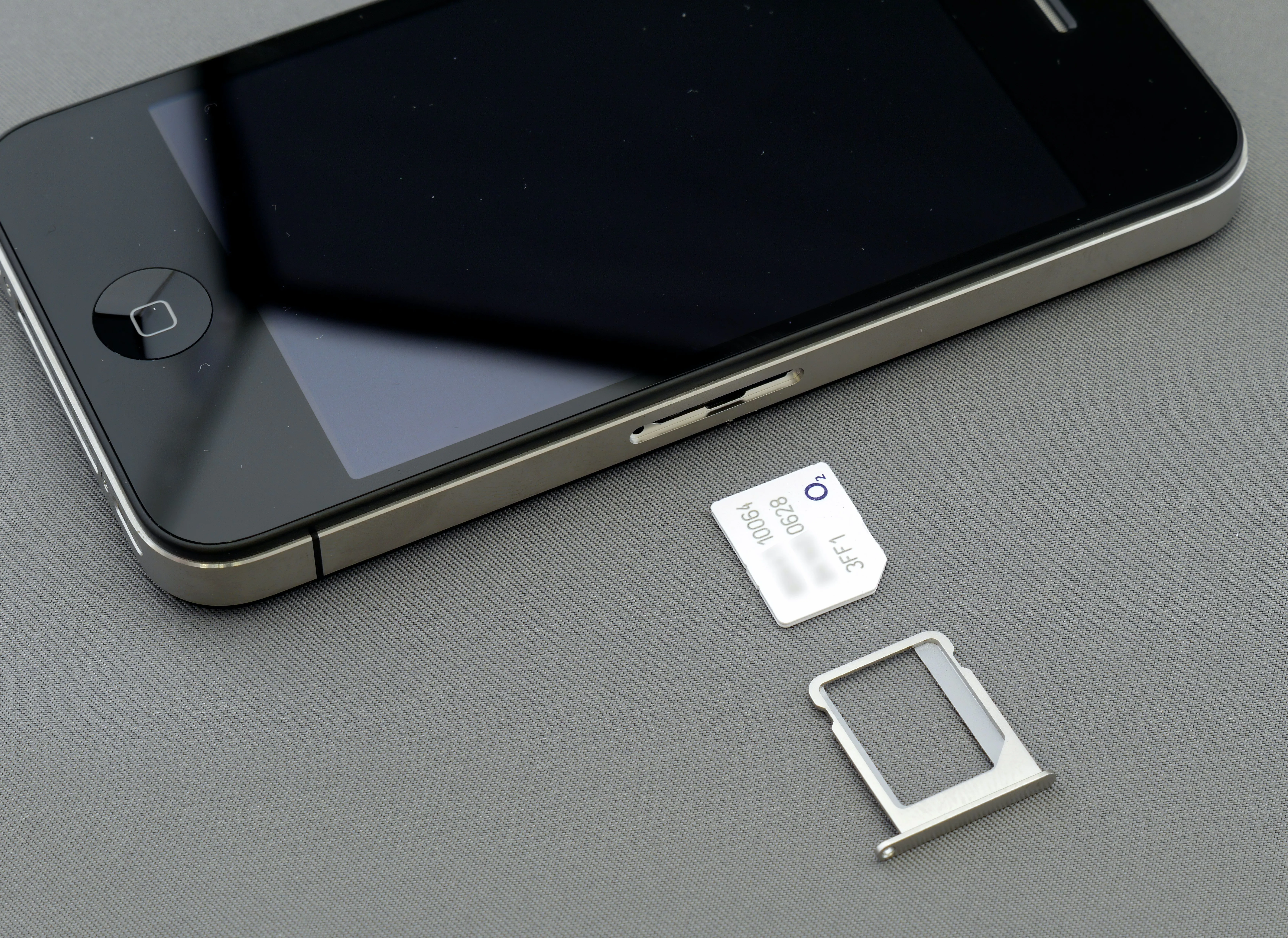 Một chiếc điện thoại iPhone đang được tháo SIM, minh họa nguy cơ tấn công SIM-swapping