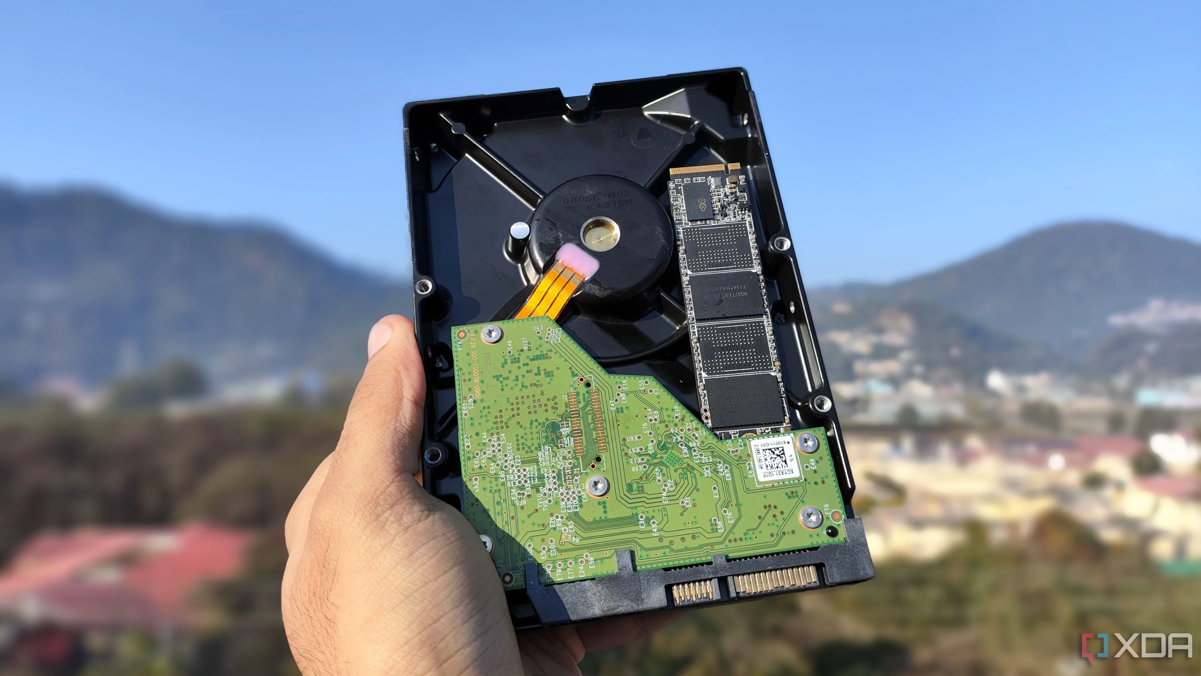 Một người cầm trên tay ổ cứng HDD và SSD, minh họa sự khác biệt về công nghệ lưu trữ và độ bền dữ liệu dài hạn
