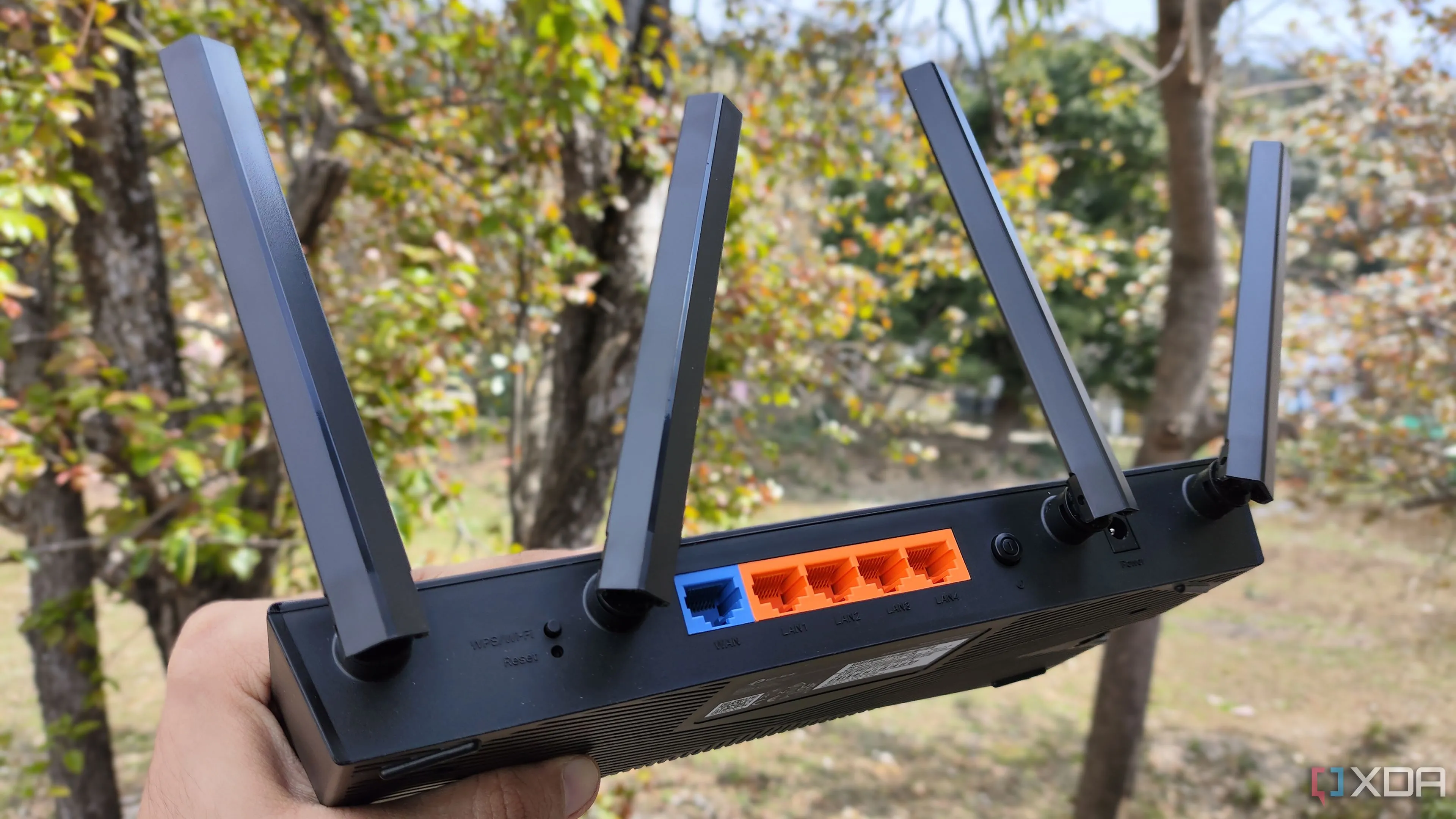 Một người đang cầm router TP-Link, gợi ý việc nâng cấp phần cứng mạng để cải thiện hiệu suất home lab