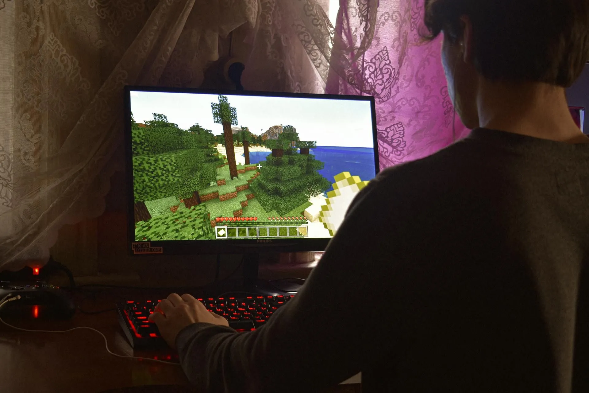 Một người đang chơi Minecraft trên laptop gaming, cho thấy sự tiện lợi và đa dạng của trải nghiệm chơi game trên PC dù có sự cạnh tranh từ game di động