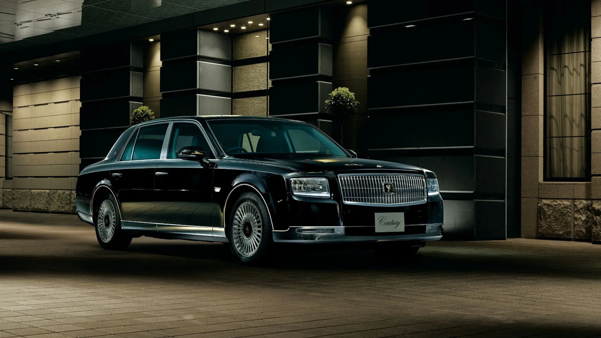 Ngoại thất phía trước bên phải của Toyota Century 2018 màu đen đỗ bên ngoài một tòa nhà