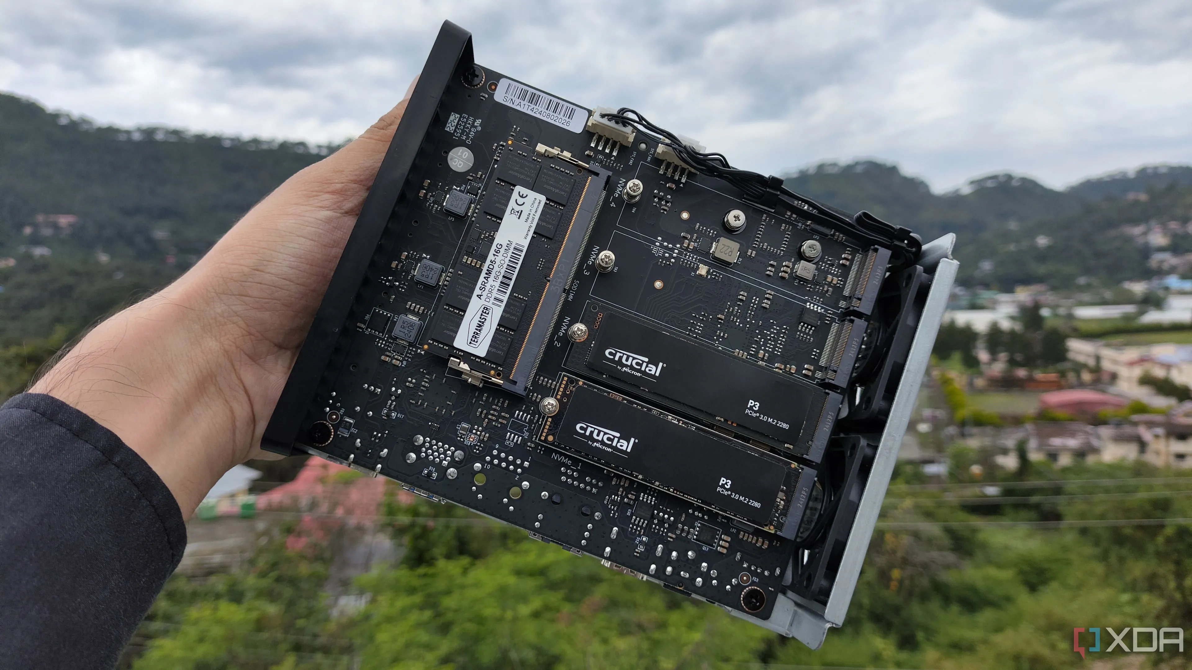 Người dùng cầm TerraMaster F8 SSD Plus với hai ổ SSD PCIe 3 được lắp vào thiết bị NAS