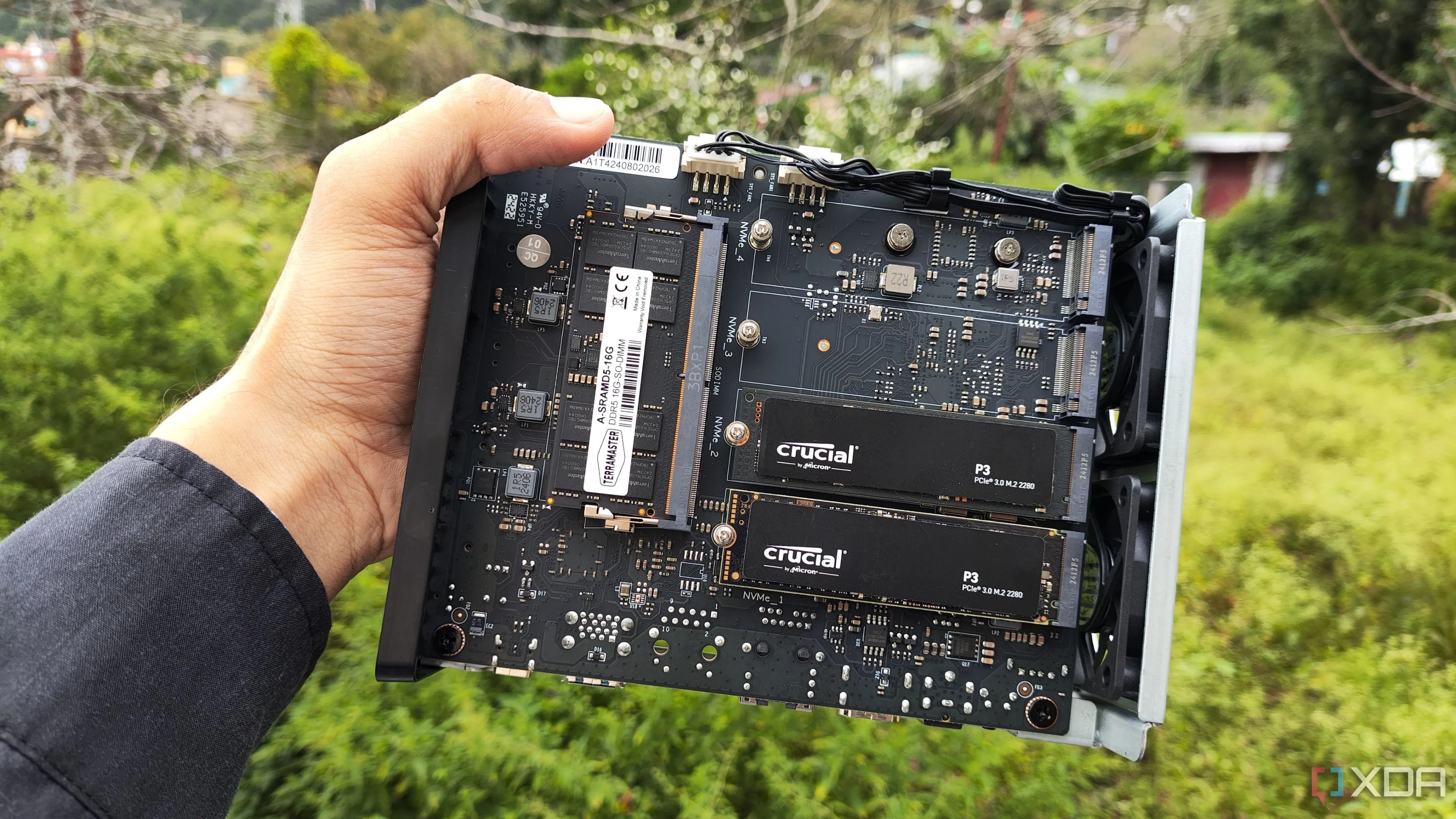 Người dùng cầm thiết bị NAS TerraMaster F8 SSD Plus với hai ổ SSD PCIe 3 được lắp sẵn