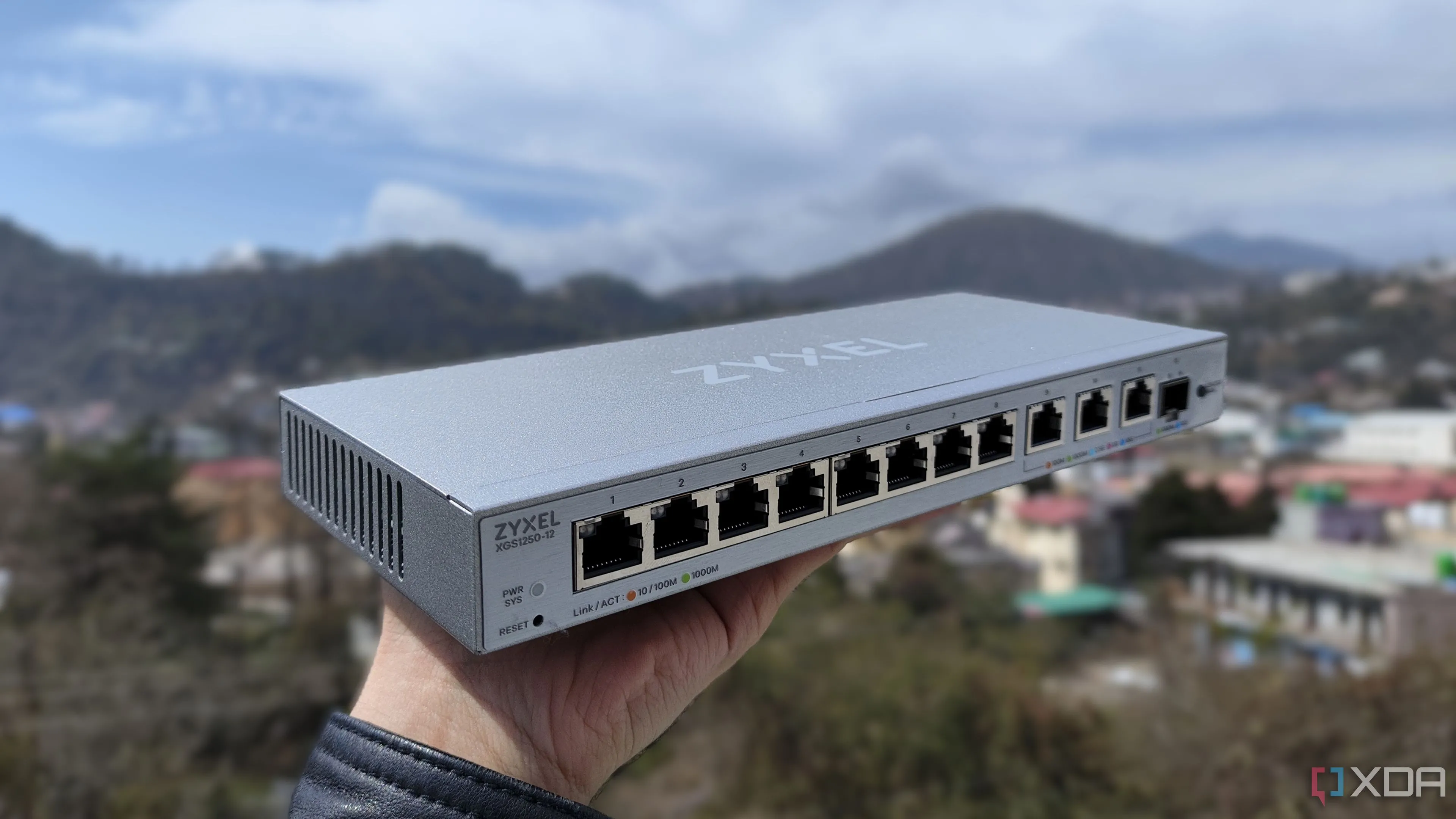 Người dùng đang cầm một switch mạng Zyxel, thiết bị cần thiết để triển khai VLAN và phân đoạn mạng