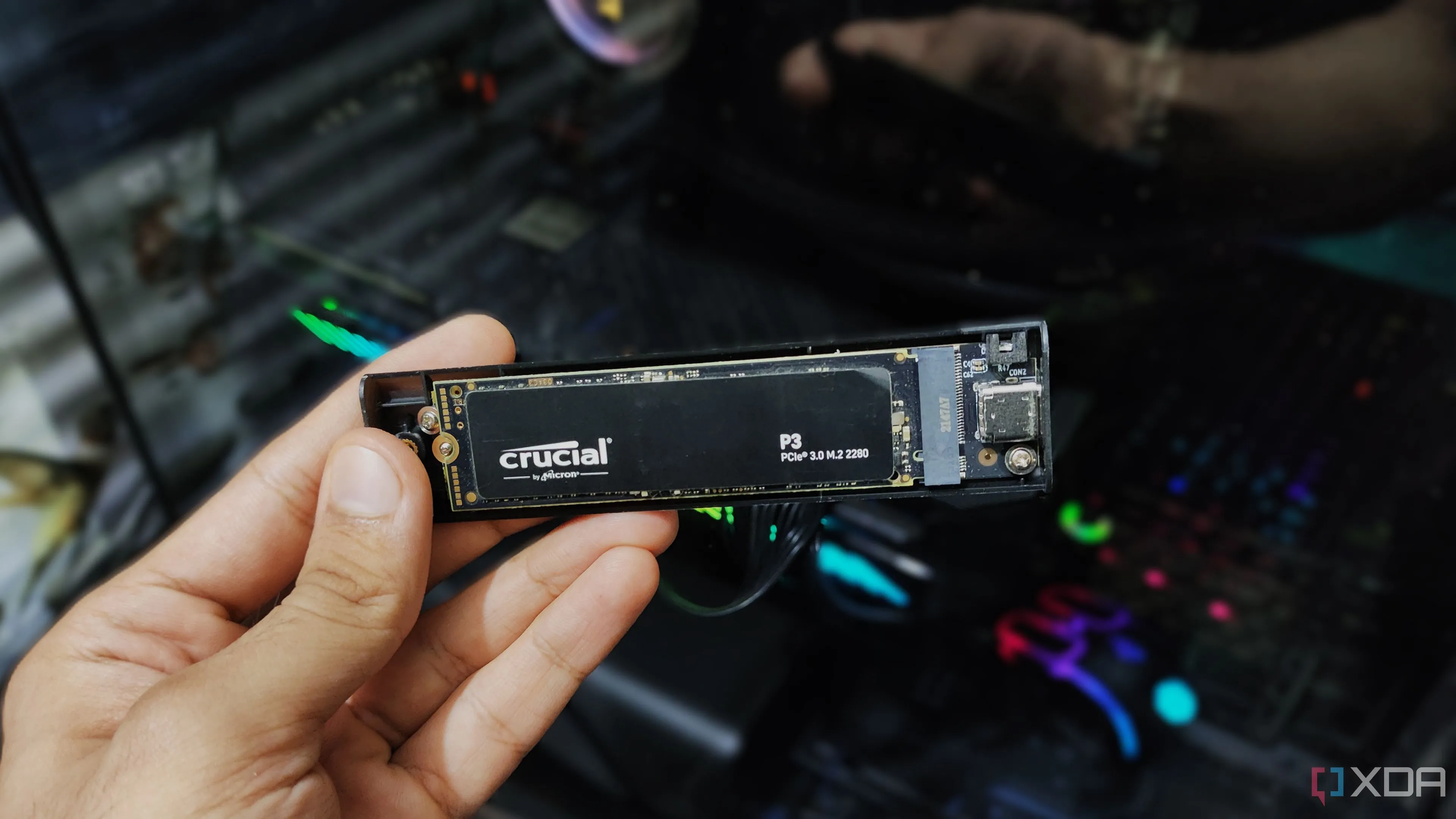 Người dùng đang cầm vỏ bọc NVMe SSD, nhấn mạnh tính di động và khả năng tùy biến của giải pháp lưu trữ này