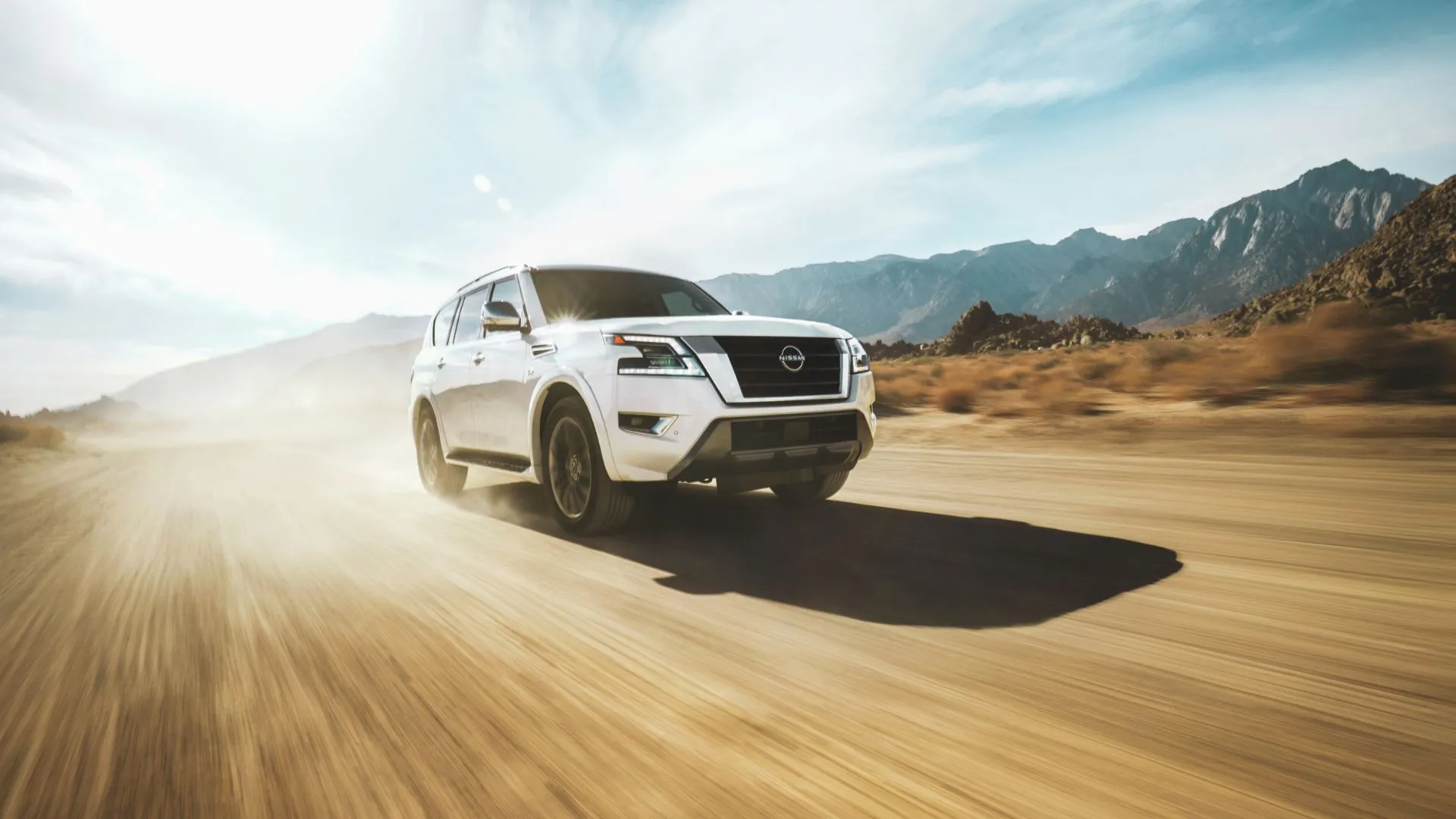 Nissan Armada 2023 màu trắng đang off-road trên sa mạc, cho thấy sức mạnh động cơ V8 và khả năng vận hành vượt trội của SUV cỡ lớn đã qua sử dụng.