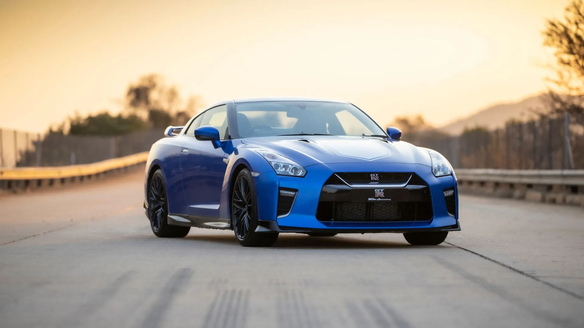 Nissan GT-R 50th Anniversary Edition 2020 màu xanh lam đỗ nghiêng trên mặt đường nhựa