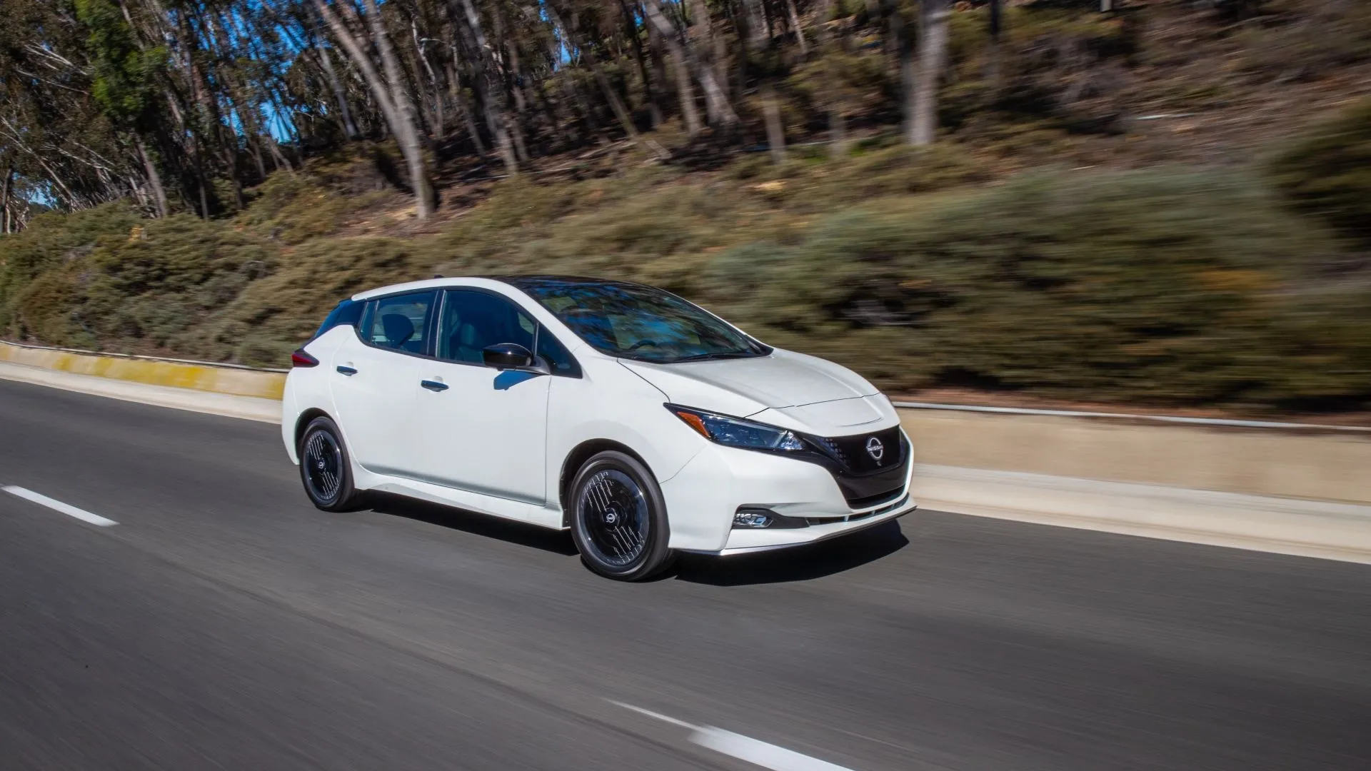 Nissan Leaf 2024 màu trắng nhìn từ góc trước khi đang chạy, đại diện cho một trong những xe điện tiên phong có tỷ lệ khấu hao đáng kể