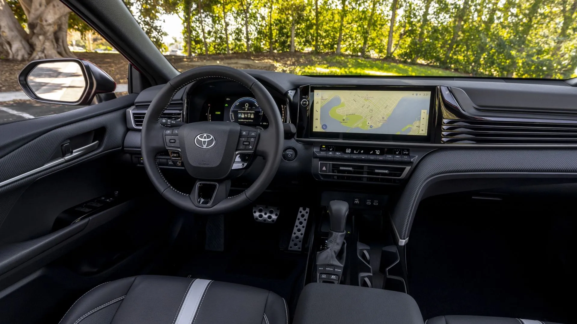 Nội thất bảng điều khiển của Toyota Camry 2025 phiên bản SE màu đen, với màn hình thông tin giải trí và các nút điều khiển vật lý