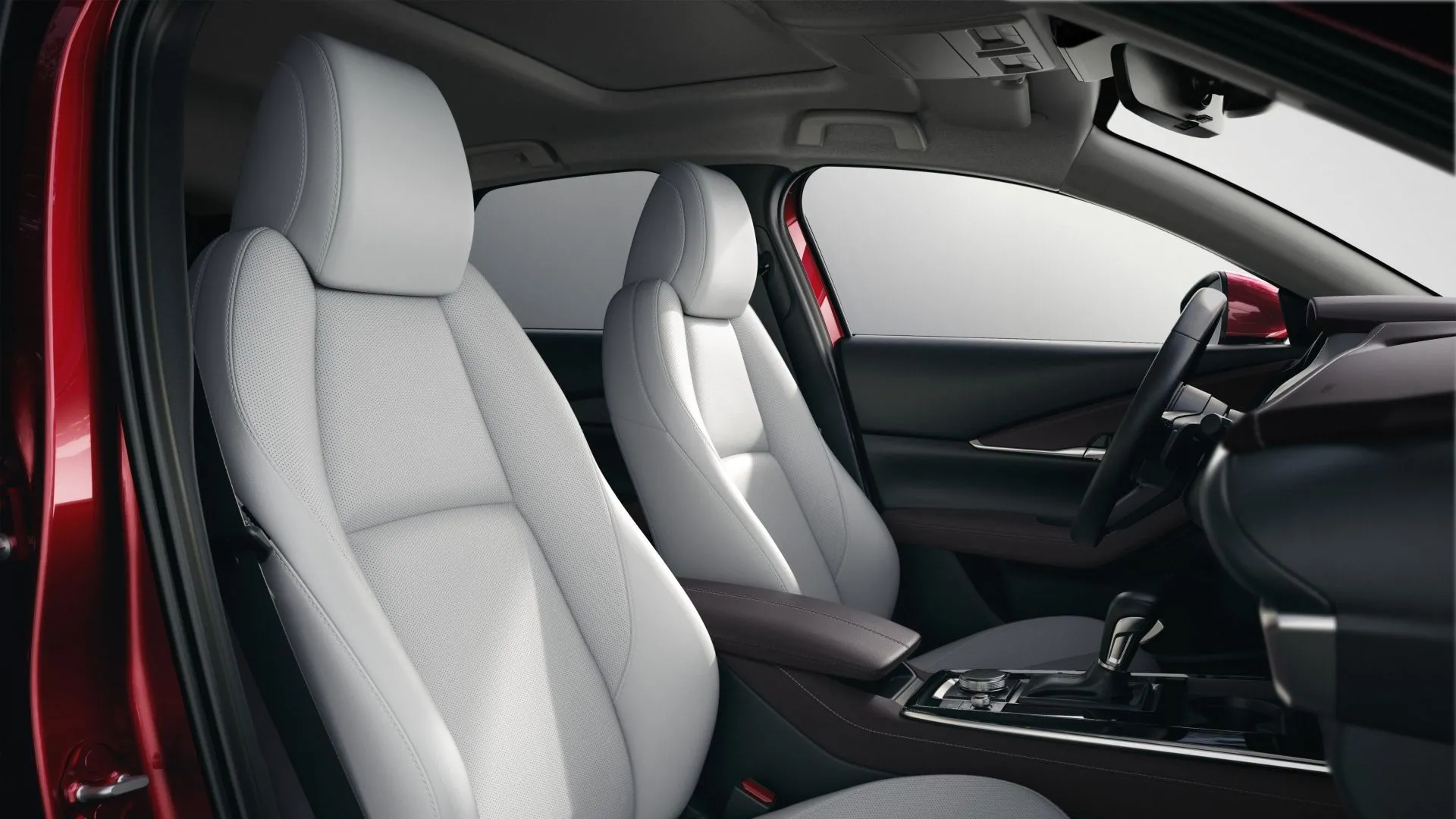 Nội thất khu vực ghế trước của một chiếc Mazda CX-30 2023 với ghế bọc da và các nút điều khiển nhiệt độ.