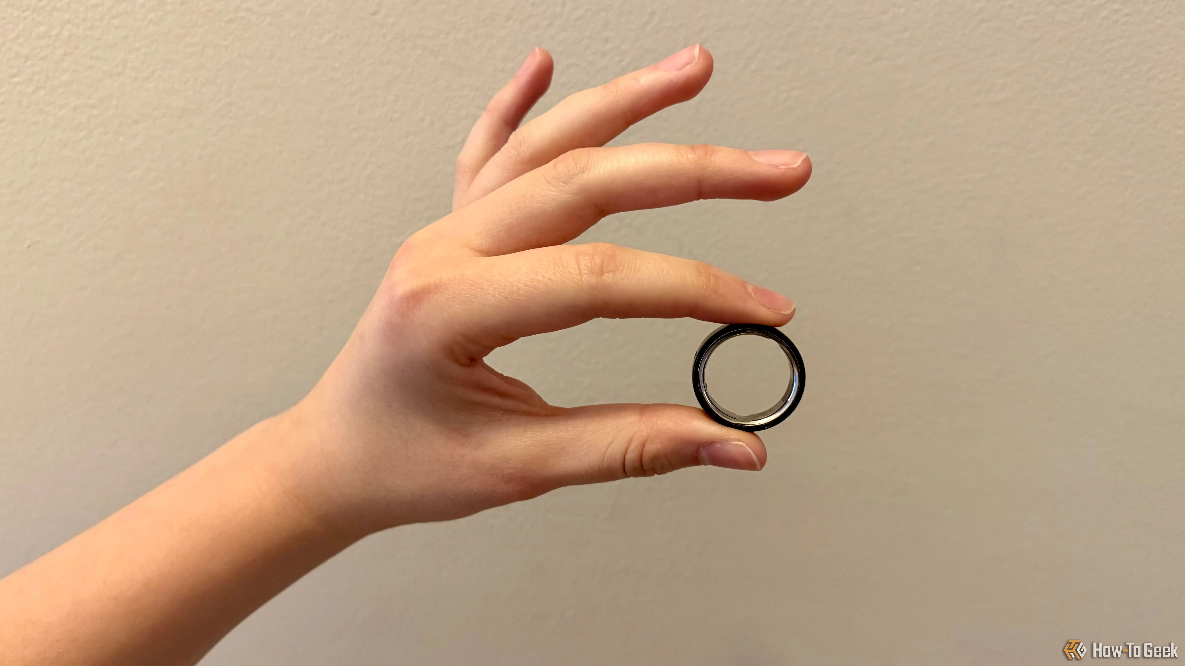 Oura Ring 4 được giữ giữa ngón trỏ và ngón cái