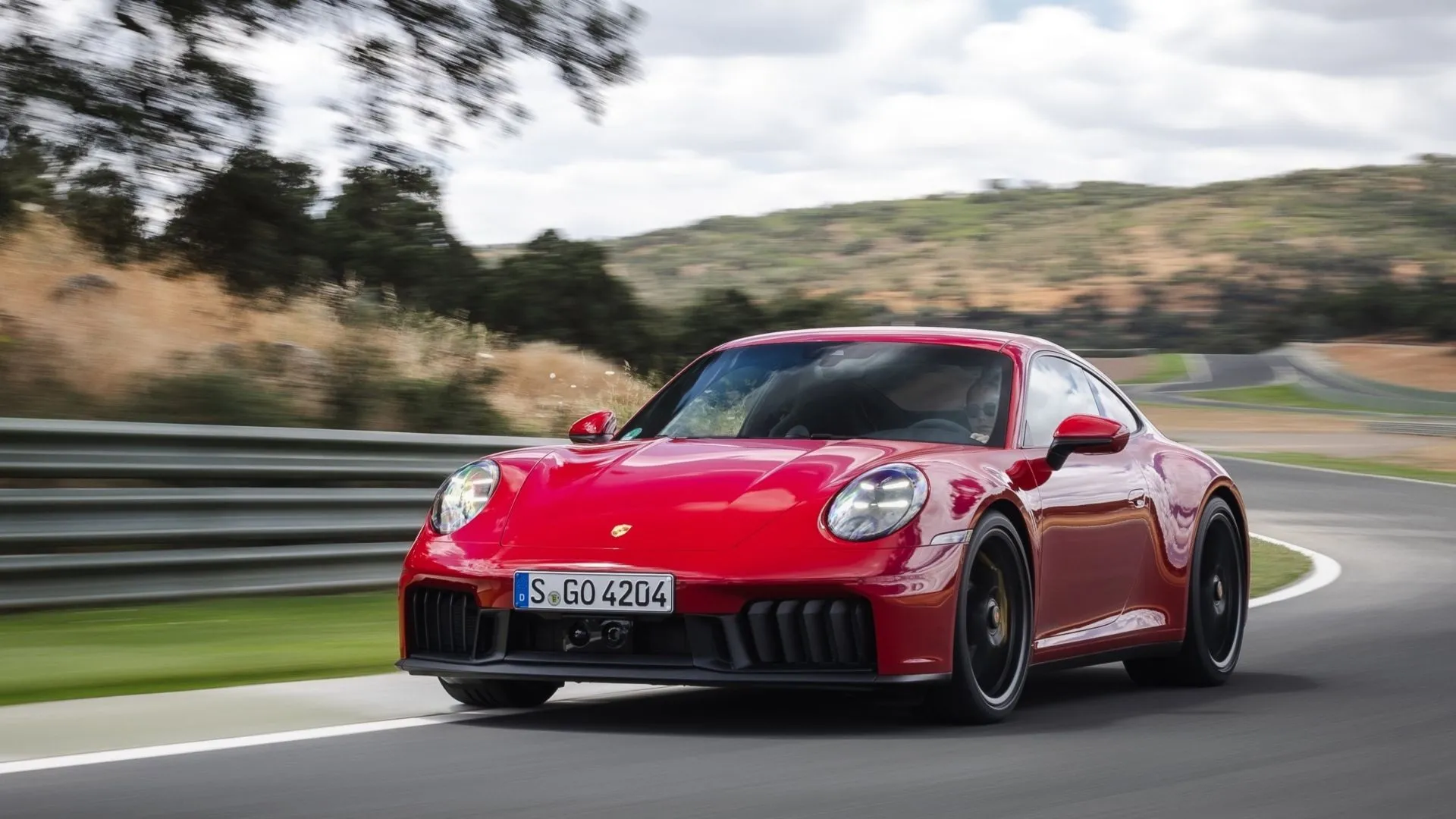 Porsche 911 Carrera 4 GTS 2025 màu trắng đang chạy trên đường đua