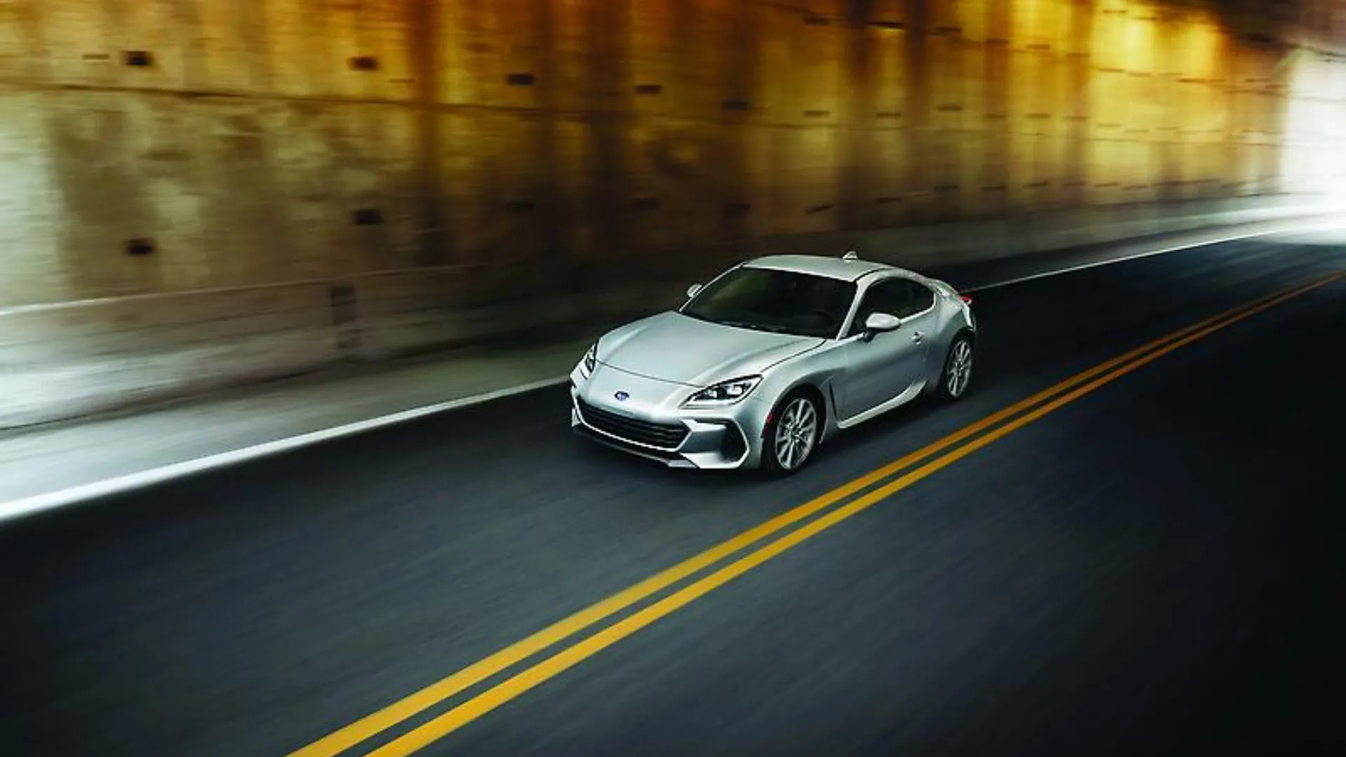 Subaru BRZ 2024 màu bạc đang chạy qua hầm cầu vượt, góc 3/4 phía trước