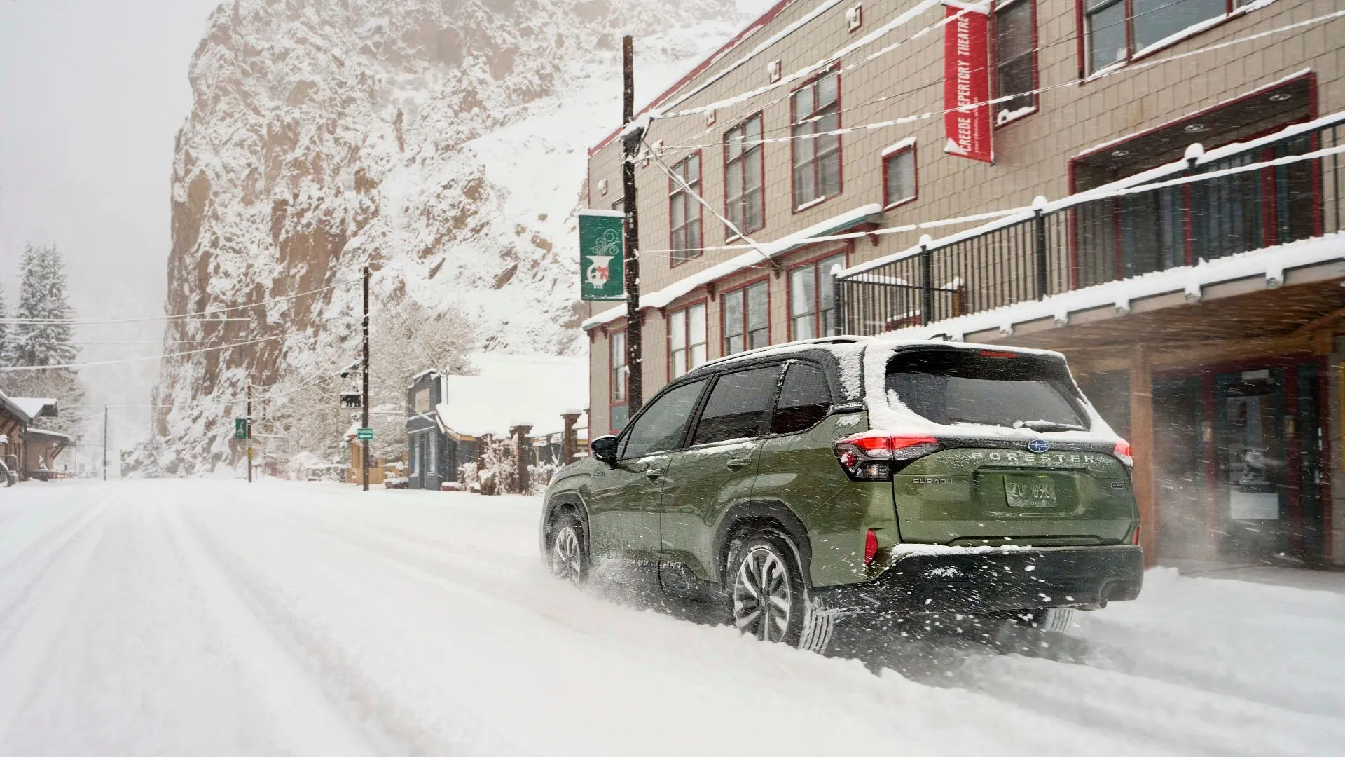 Subaru Forester Hybrid 2025 màu xanh lá di chuyển trên đường tuyết trong thành phố