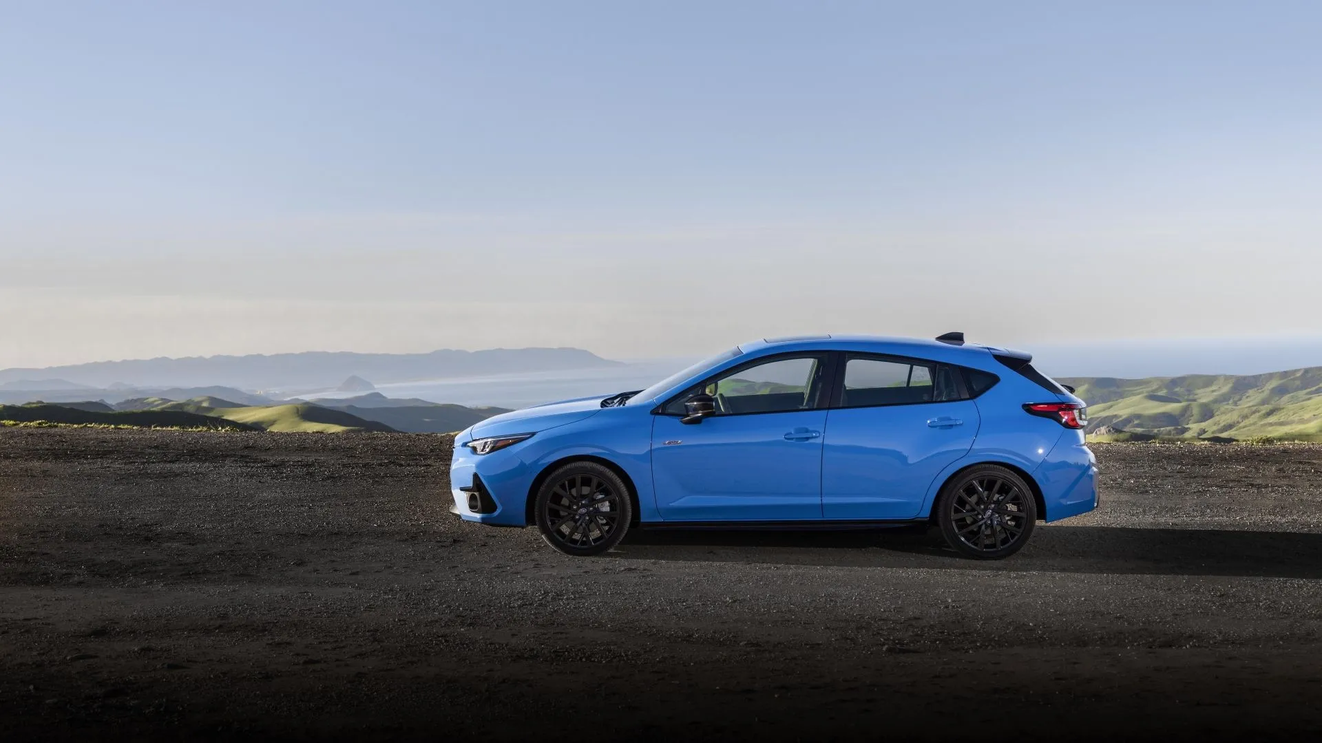 Subaru Impreza RS 2024 màu xanh nhìn từ góc nghiêng, nhấn mạnh vẻ ngoài thể thao và mạnh mẽ