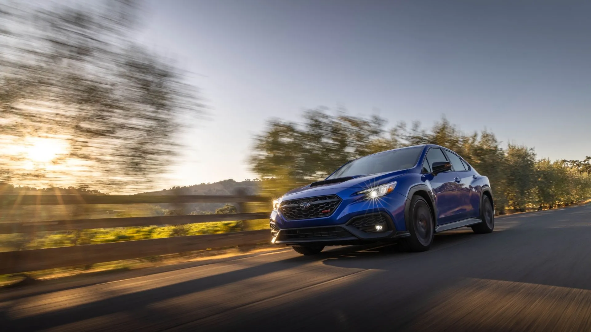 Subaru WRX tS 2025 màu xanh dương đang tăng tốc trên đường, thể hiện vẻ năng động và khả năng vận hành thể thao.