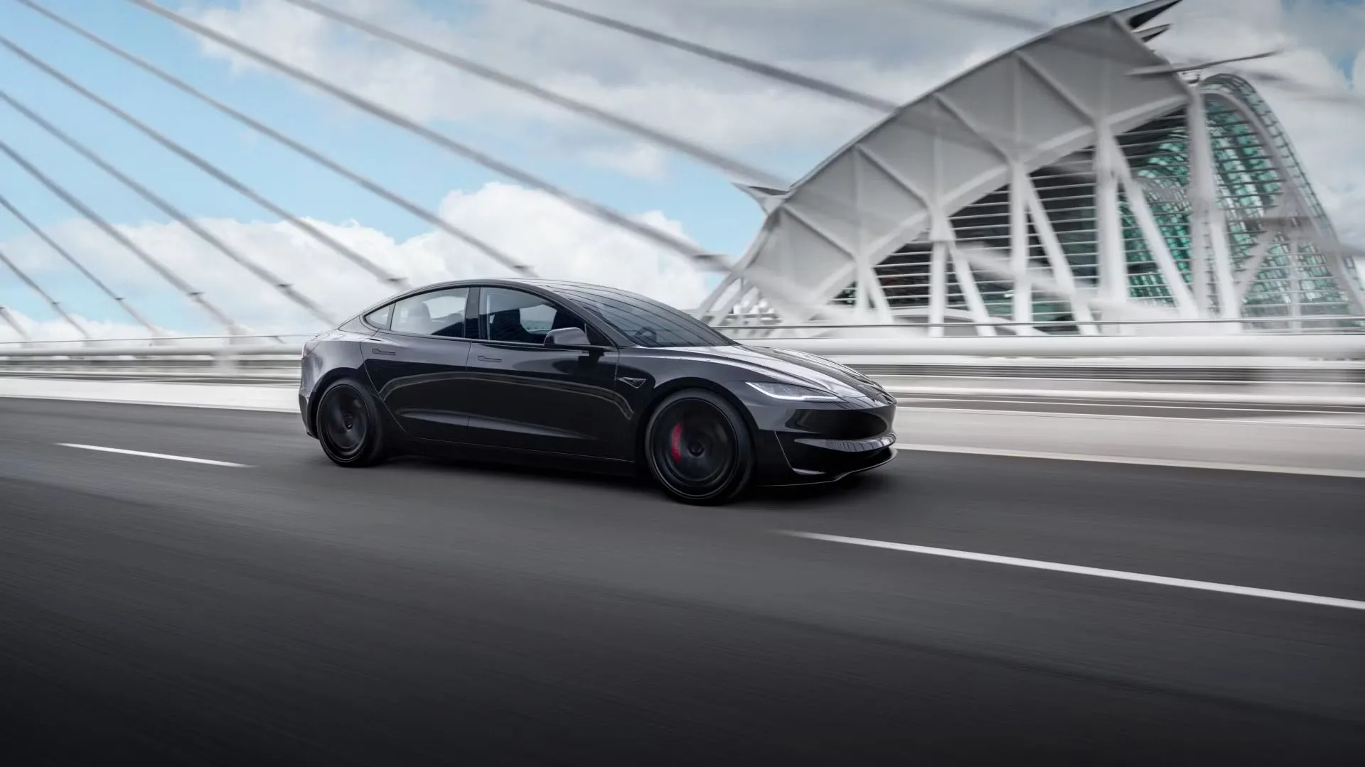 Tesla Model 3 Performance 2024 màu đen di chuyển qua cầu, nhấn mạnh khả năng tăng tốc vượt trội của mẫu sedan điện này.