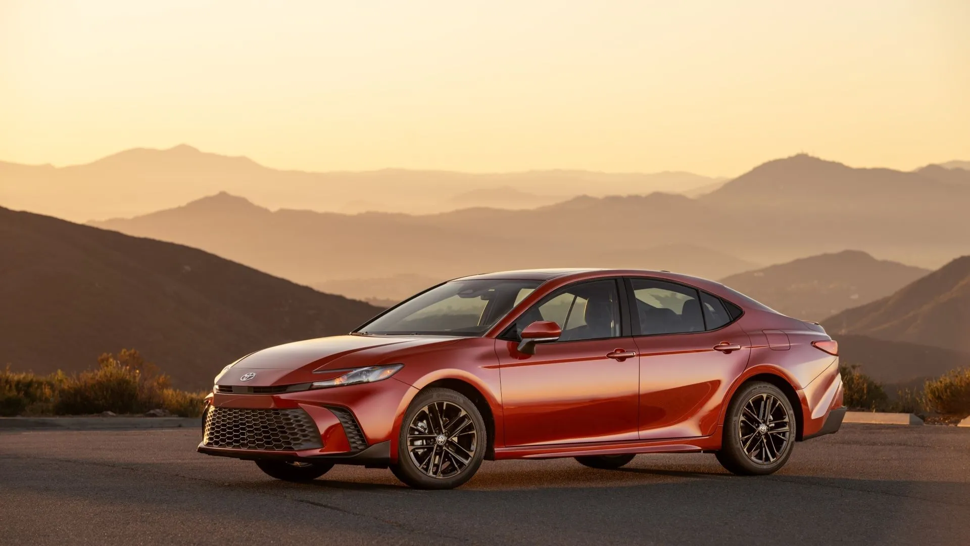 Toyota Camry Hybrid 2025 SE AWD màu đỏ Supersonic Red dưới ánh hoàng hôn