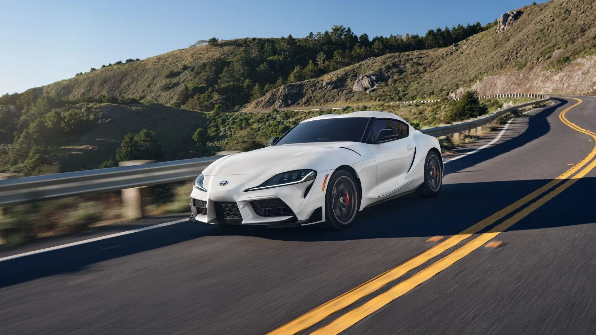 Toyota GR Supra 2025 màu trắng đang chạy trên cung đường đèo, xe thể thao Nhật Bản