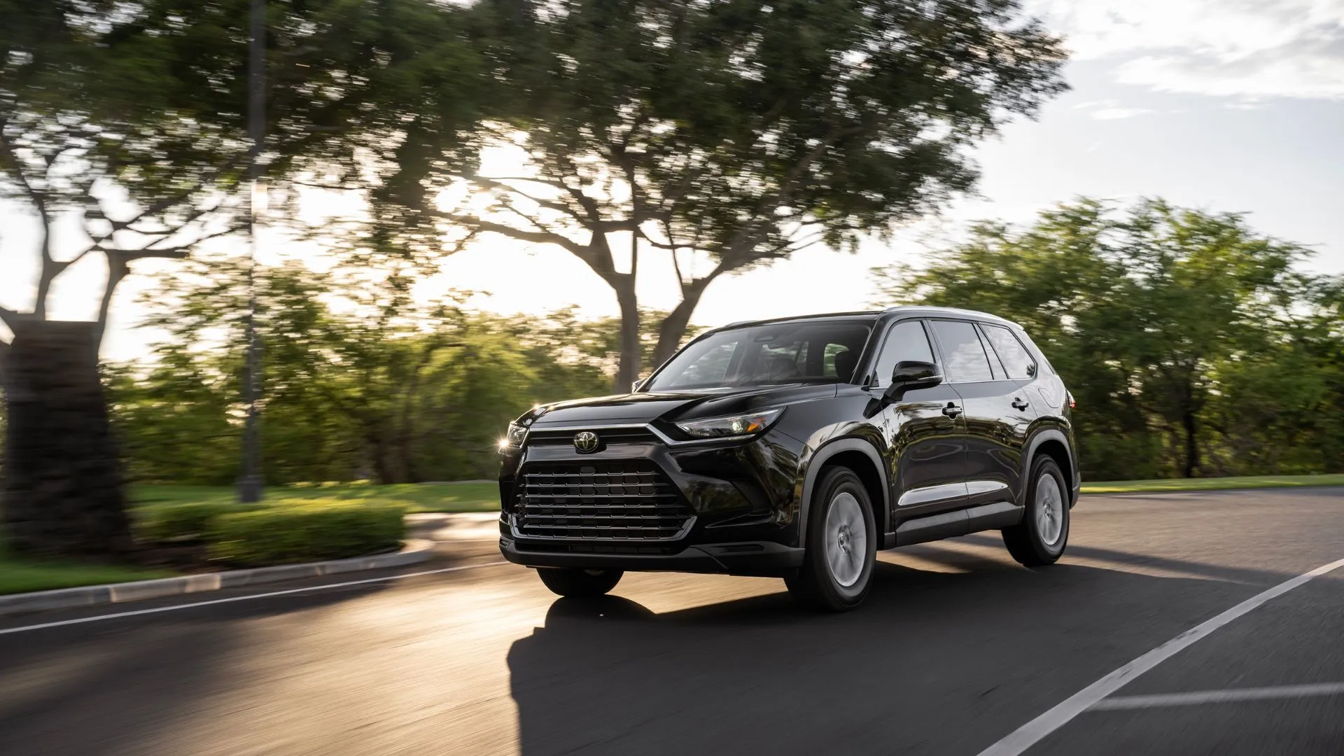 Toyota Grand Highlander Hybrid 2025 màu xanh dương đang di chuyển trên đường, thể hiện không gian rộng rãi